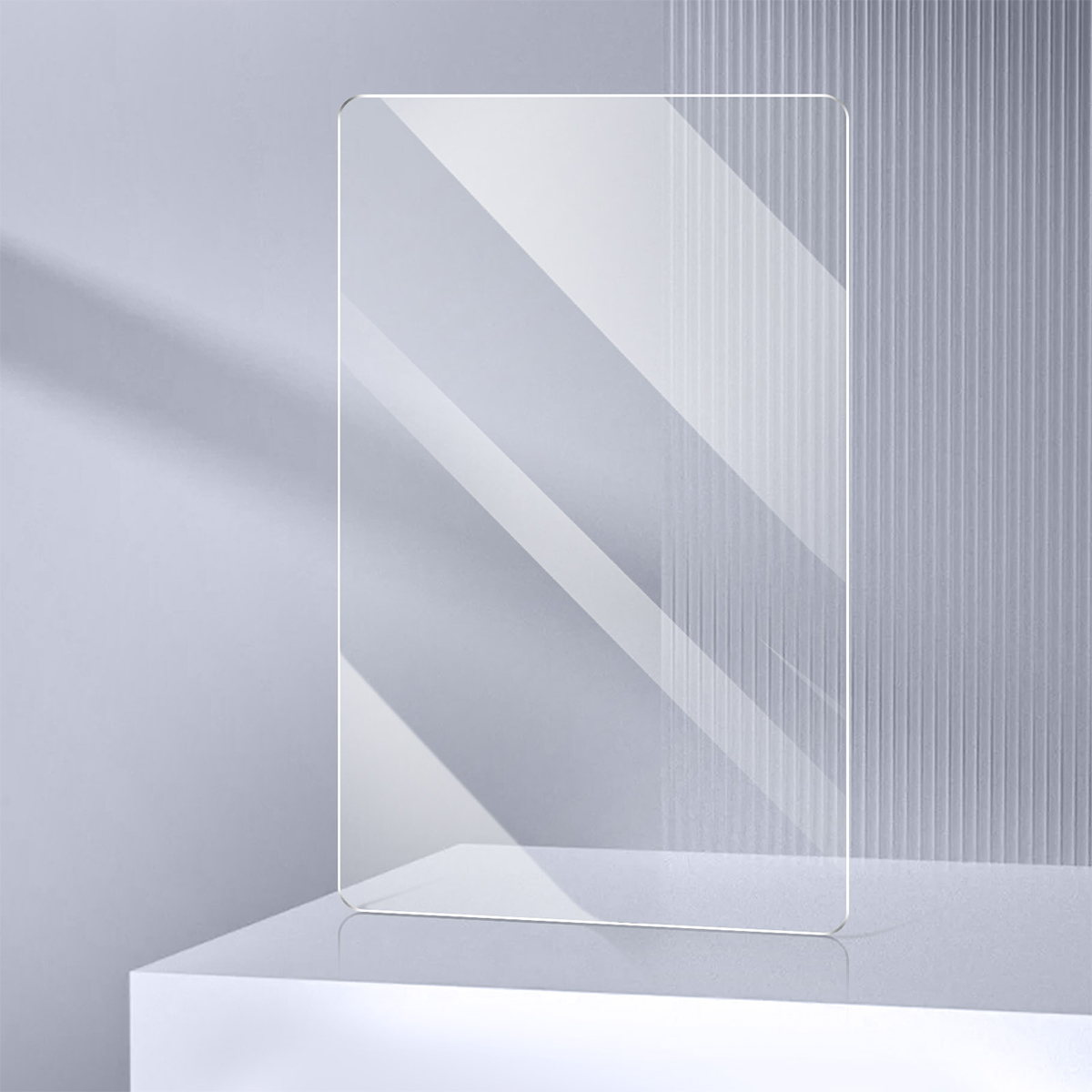 Un protecteur d'écran rectangulaire en verre trempé transparent se tient debout sur une surface blanche, avec des ombres douces.