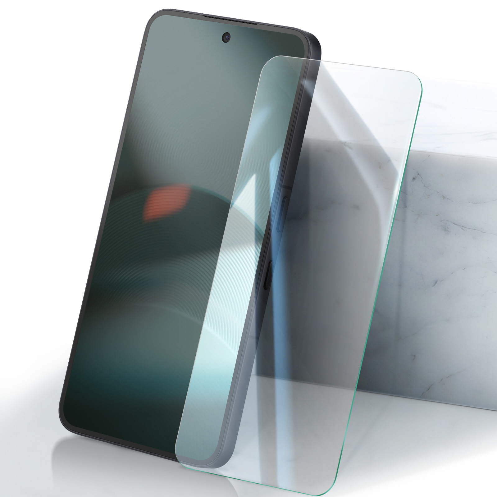 Un smartphone gris foncé avec protection d'écran sur surface blanche à côté d'un bloc de marbre.