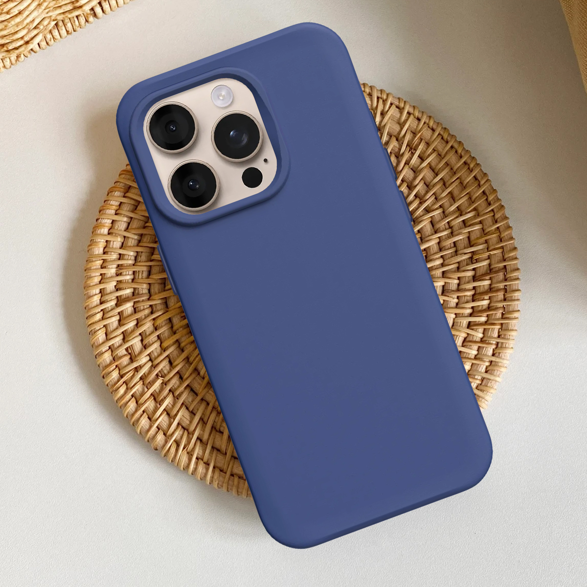Een blauwe telefoonhoes met drie camera's op een gevlochten onderzetter.