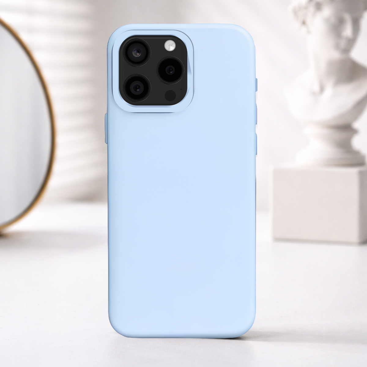 Coque iPhone bleu clair avec triple appareil photo sur table blanche.