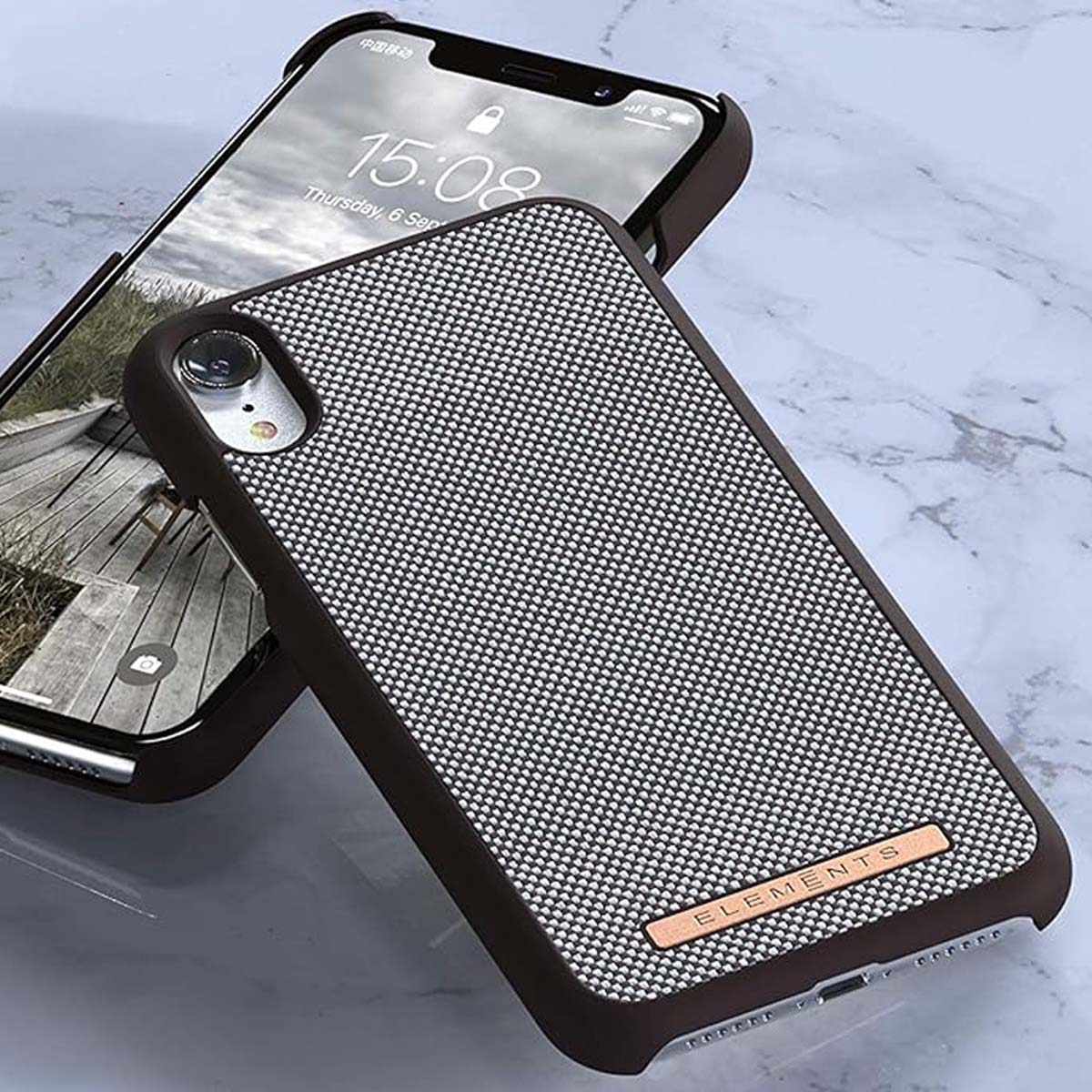 Un telefono scuro con custodia in tessuto e fotocamera. Lo schermo mostra le 15:08.
