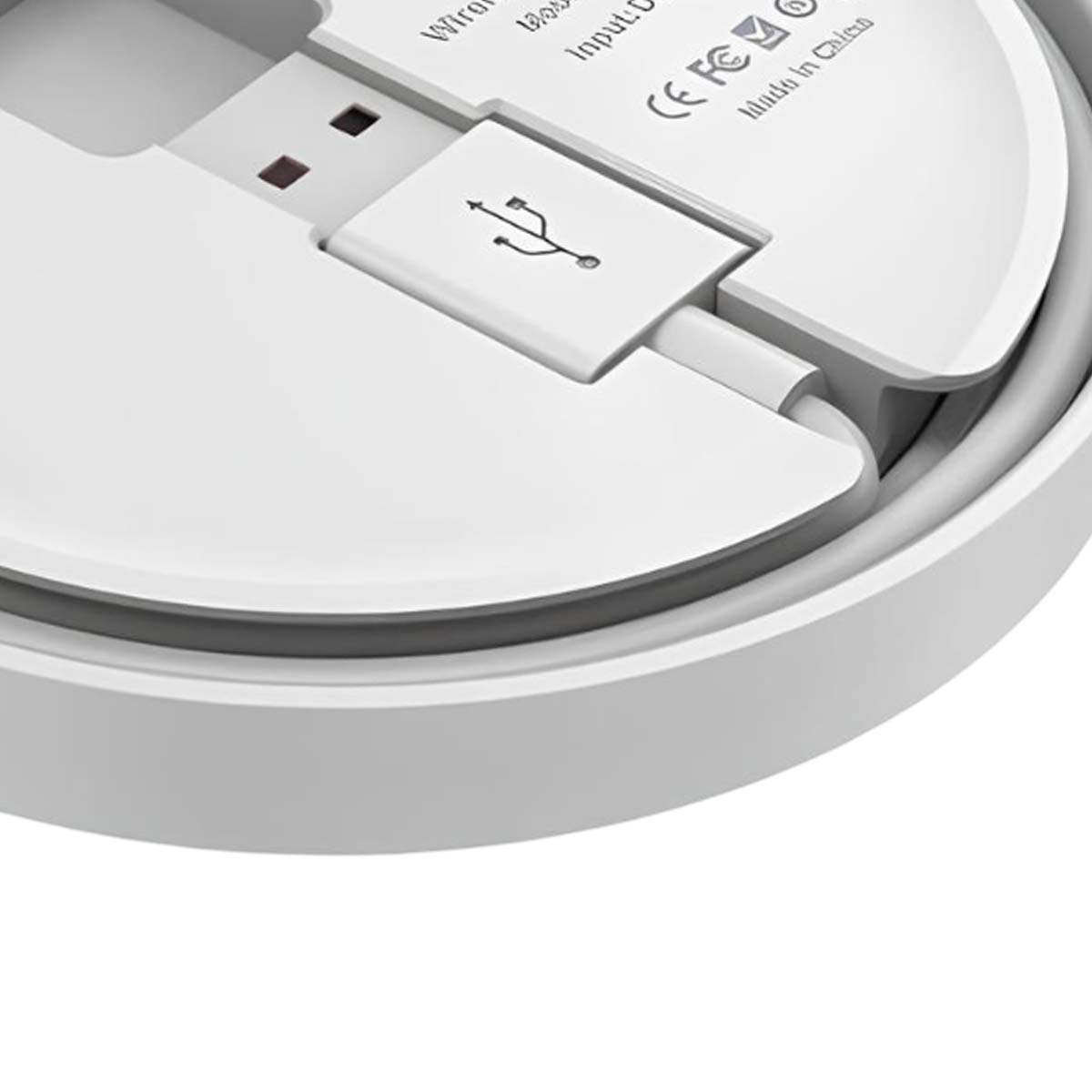 Nahaufnahme eines weißen USB-Kabels, das in ein Gerät eingesteckt ist, mit CE- und FCC-Logos.
