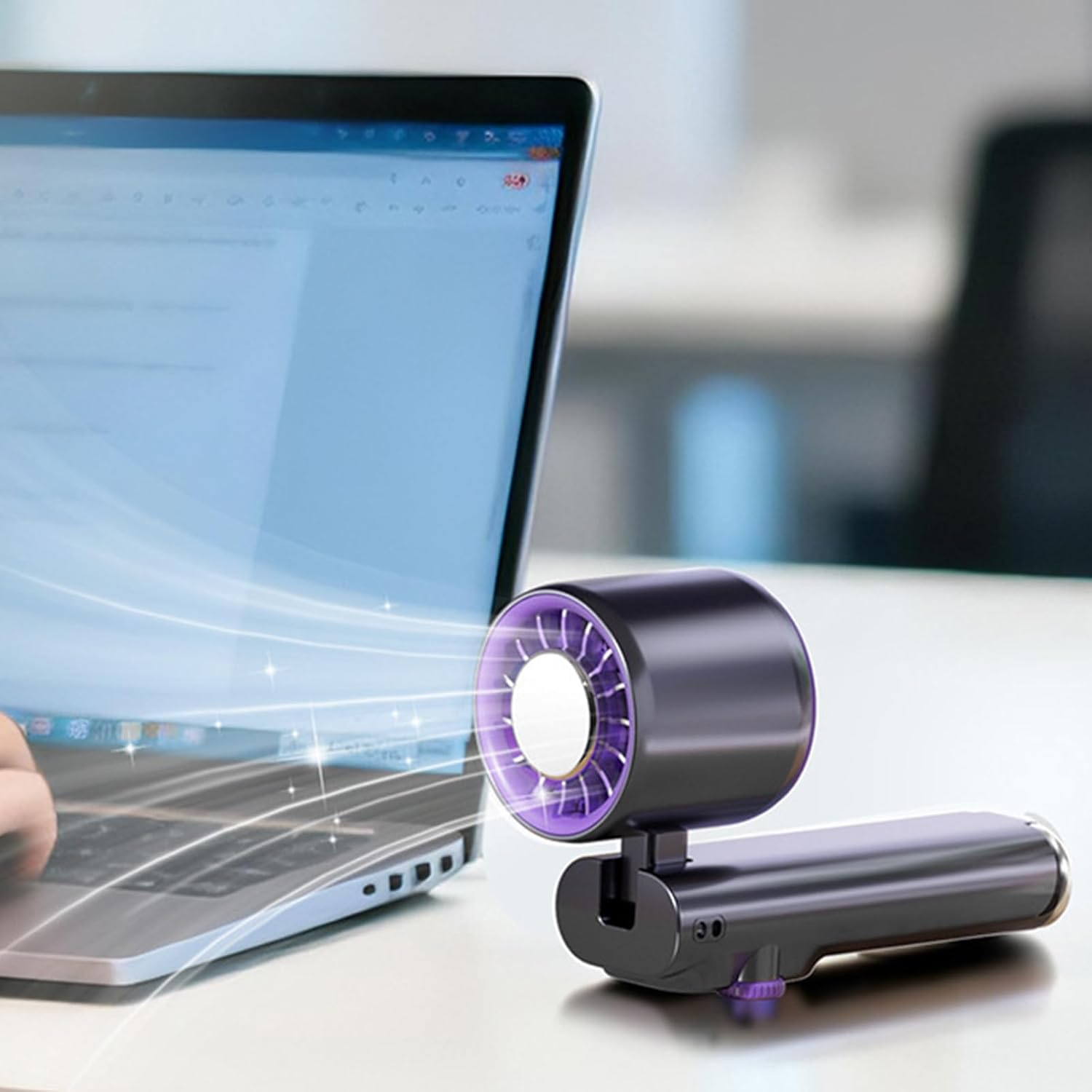 Ein violetter Lüfter mit lila Lichtern neben einem geöffneten Laptop.
