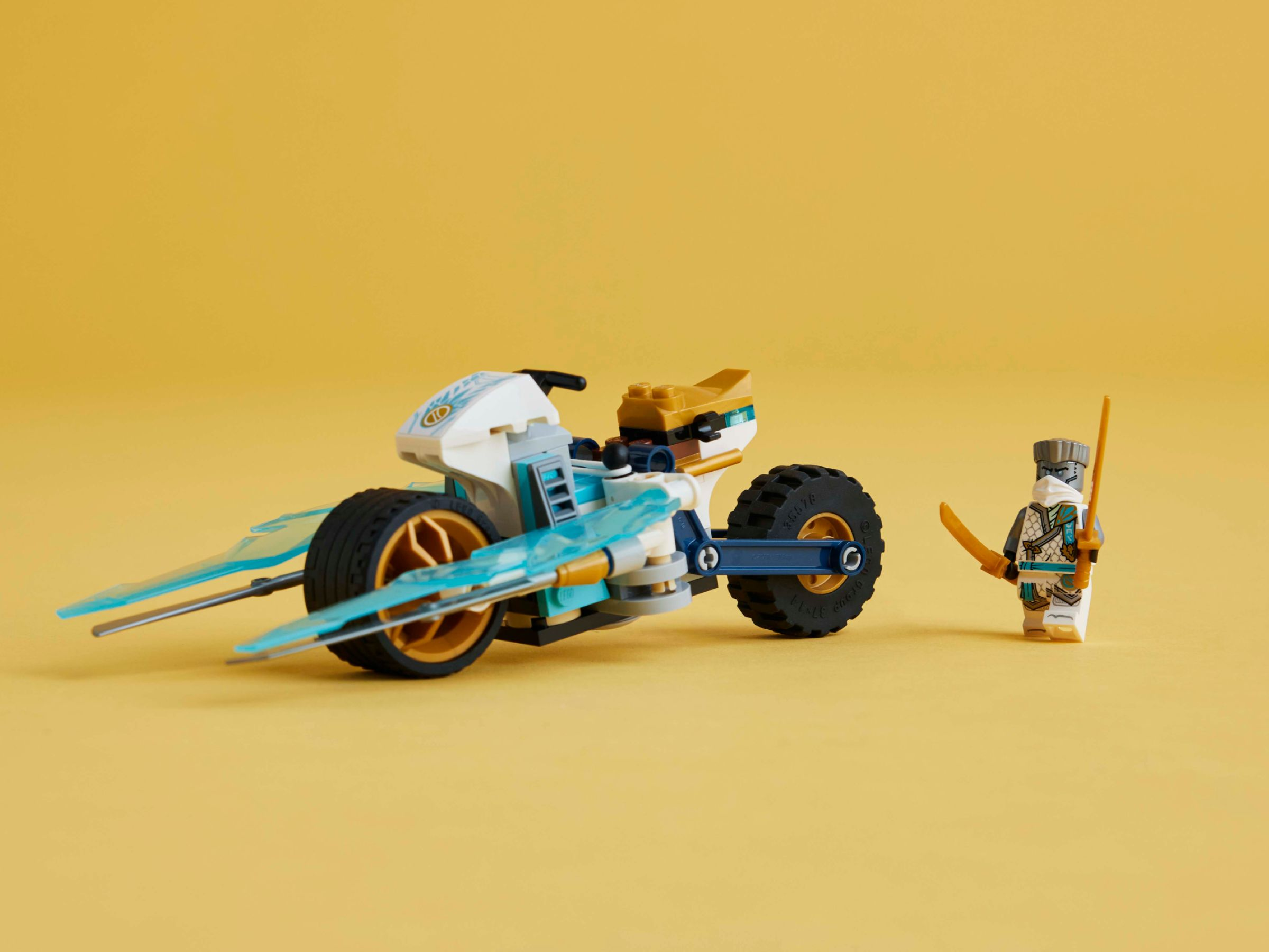 Ein Lego-Motorrad mit blauen Flügeln und ein Ninja-Charakter mit Schwertern.