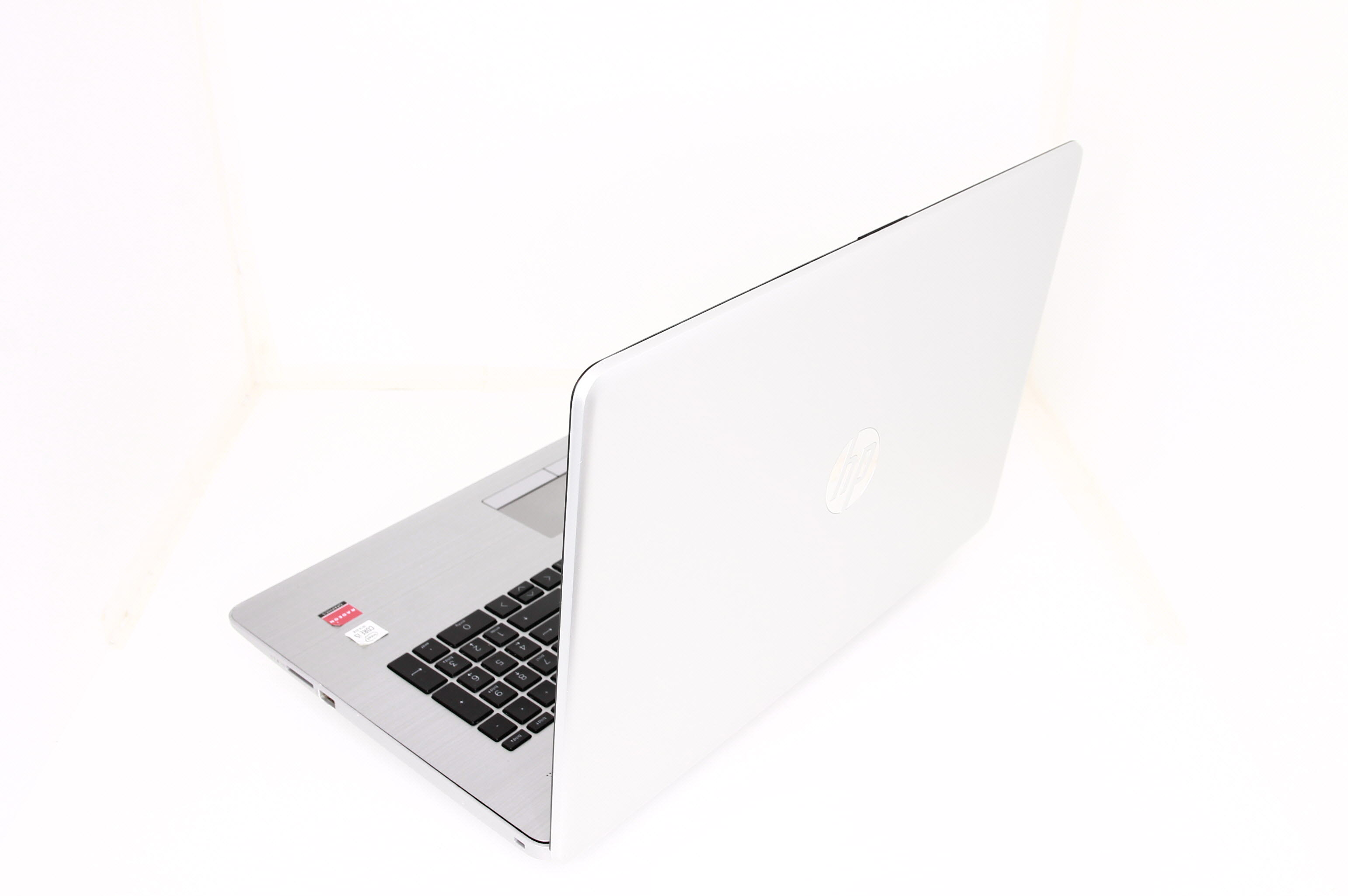 Ein silberner Laptop mit geschlossener weißer Haube, auf weißem Hintergrund.