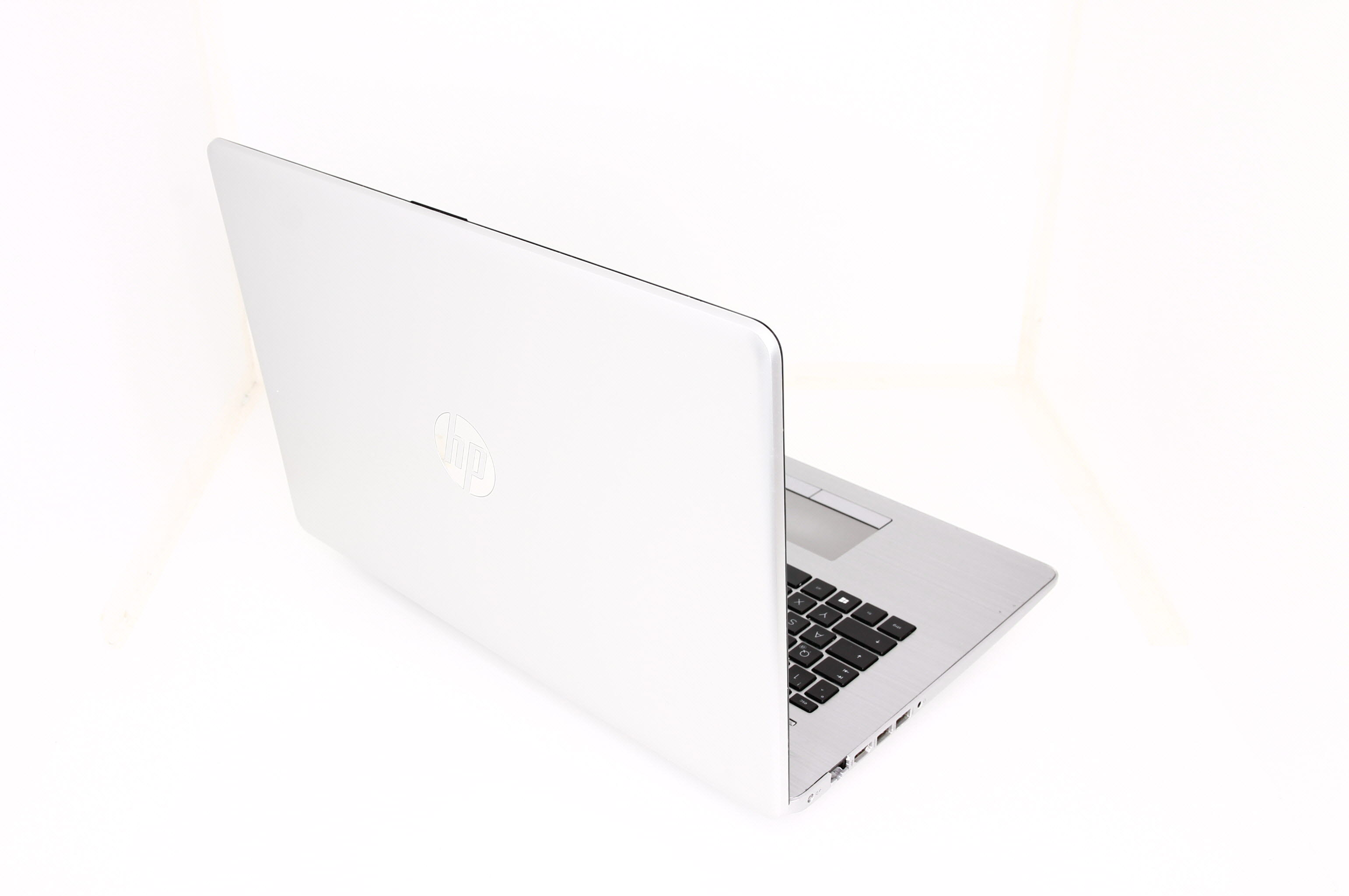 Ein silberner HP Laptop mit Tastatur und Anschlüssen auf weißem Hintergrund.