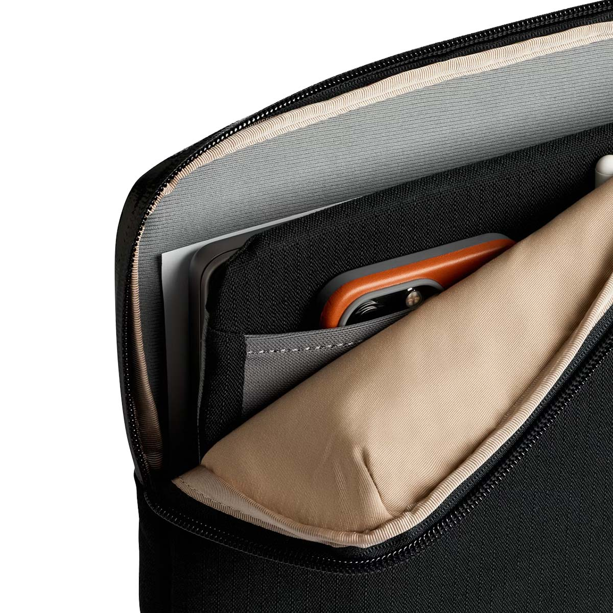 Czarna torba na laptopa z wyściełaną komorą zawierającą pomarańczowy przedmiot.