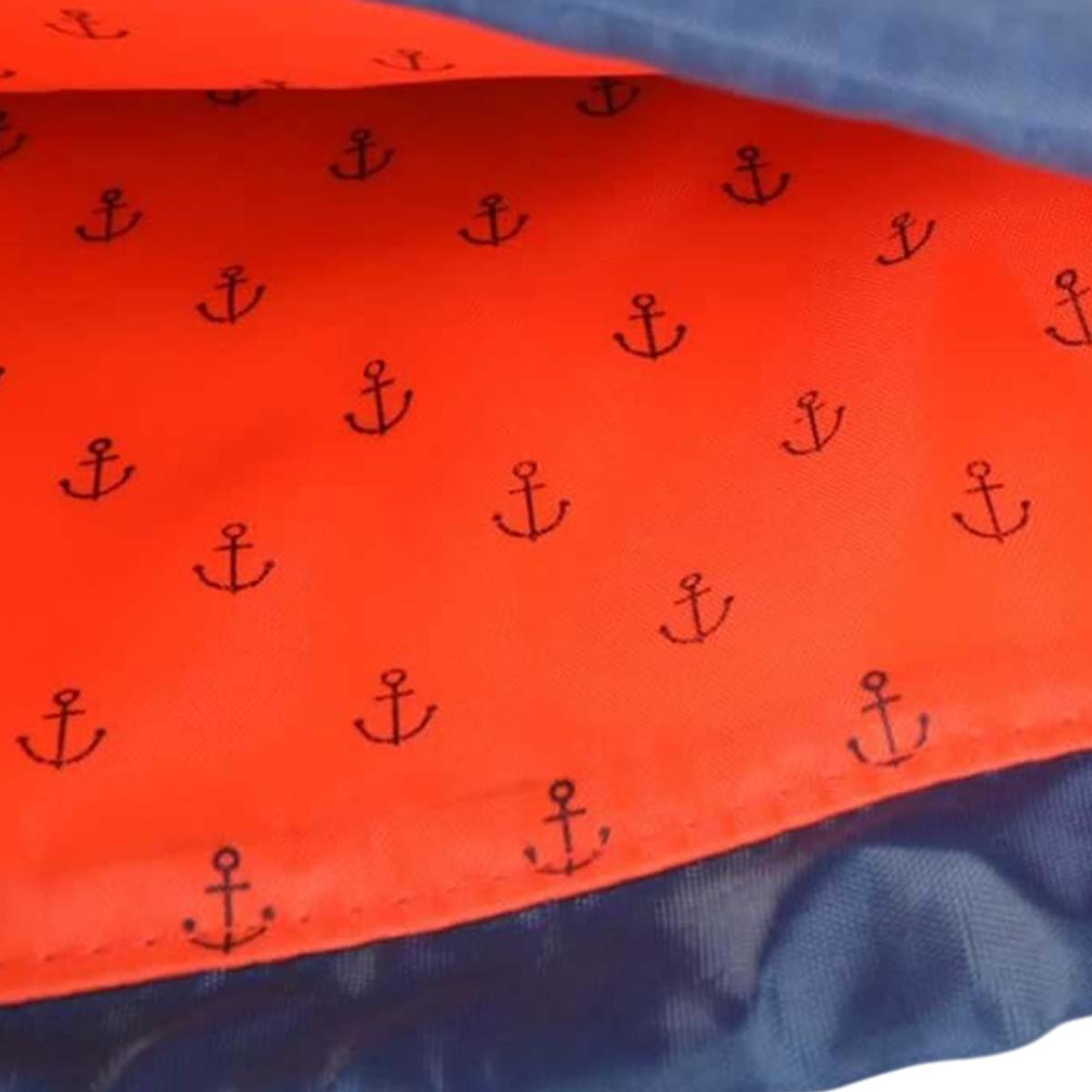 Tela naranja con anclas oscuras, superpuesta por tela azul.