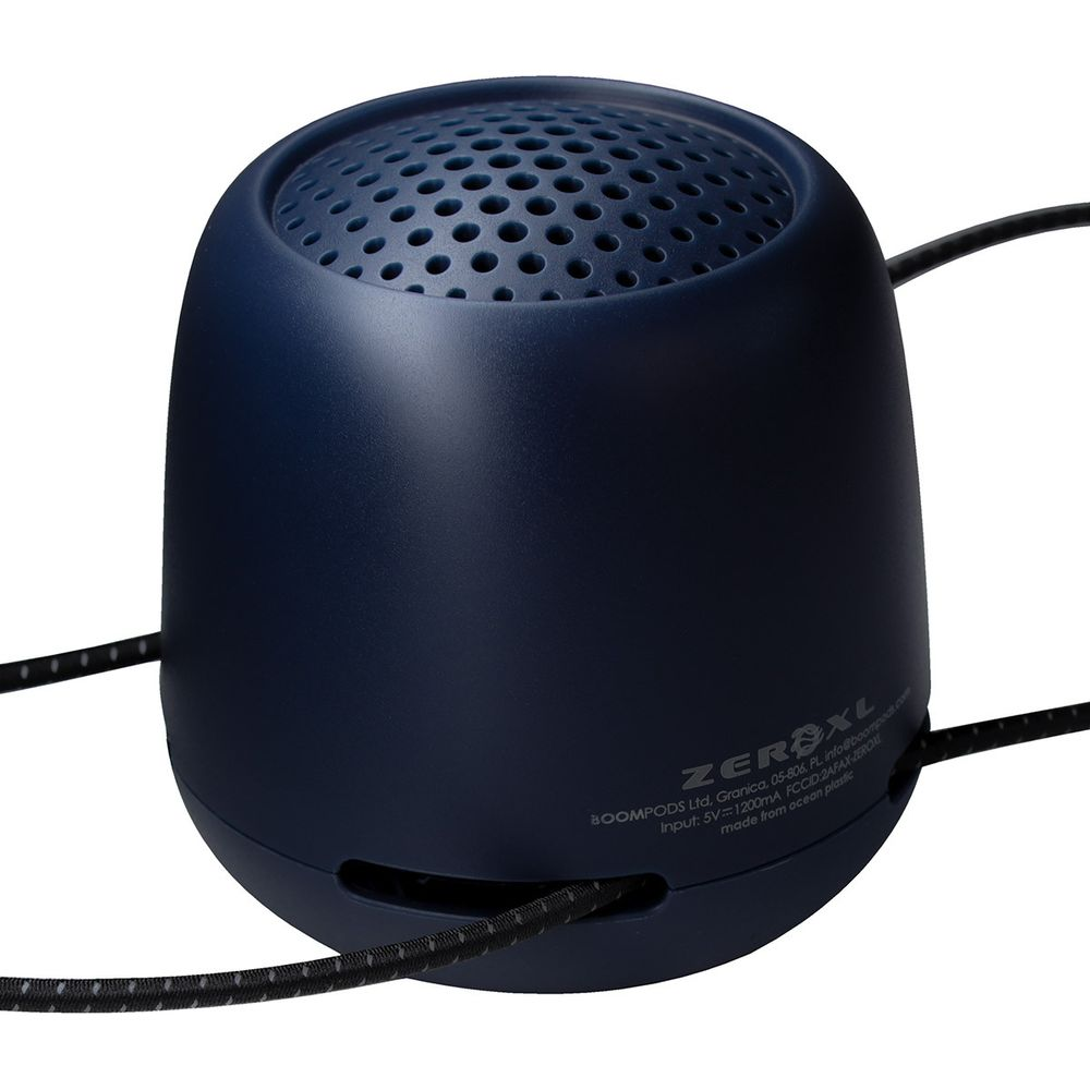 Une enceinte bleu foncé, ronde, avec un dessus perforé et un câble noir.