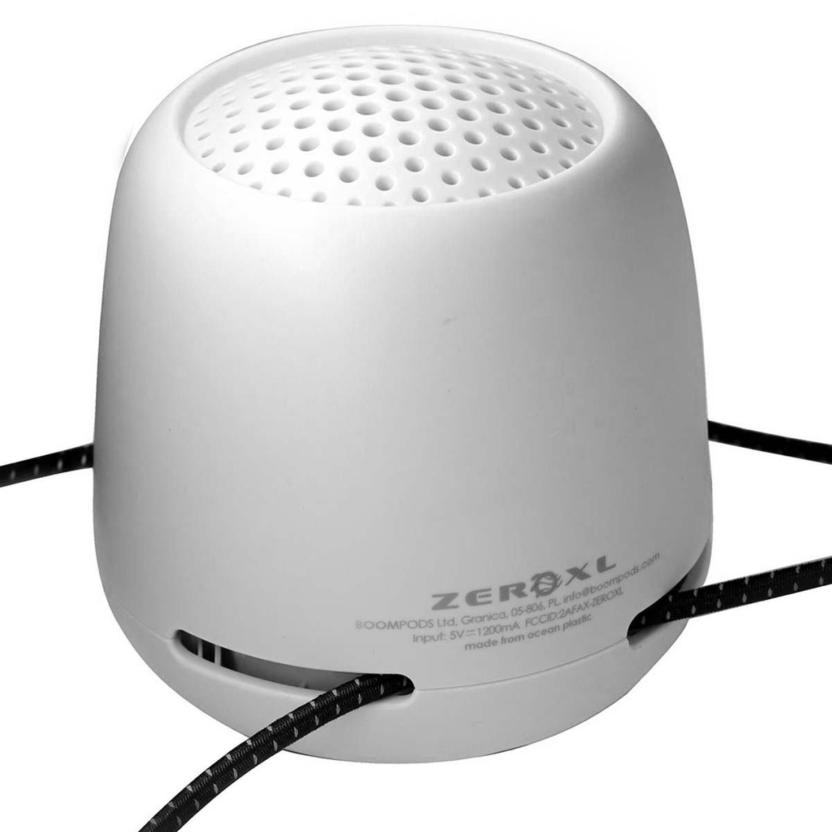 Une enceinte blanche avec un motif perforé en haut et un cordon noir.