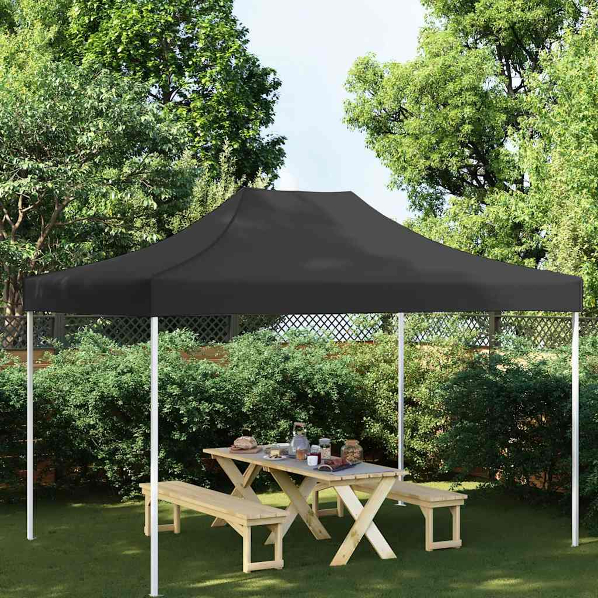 Una tenda a baldacchino nera su un tavolo da picnic in legno con panche.