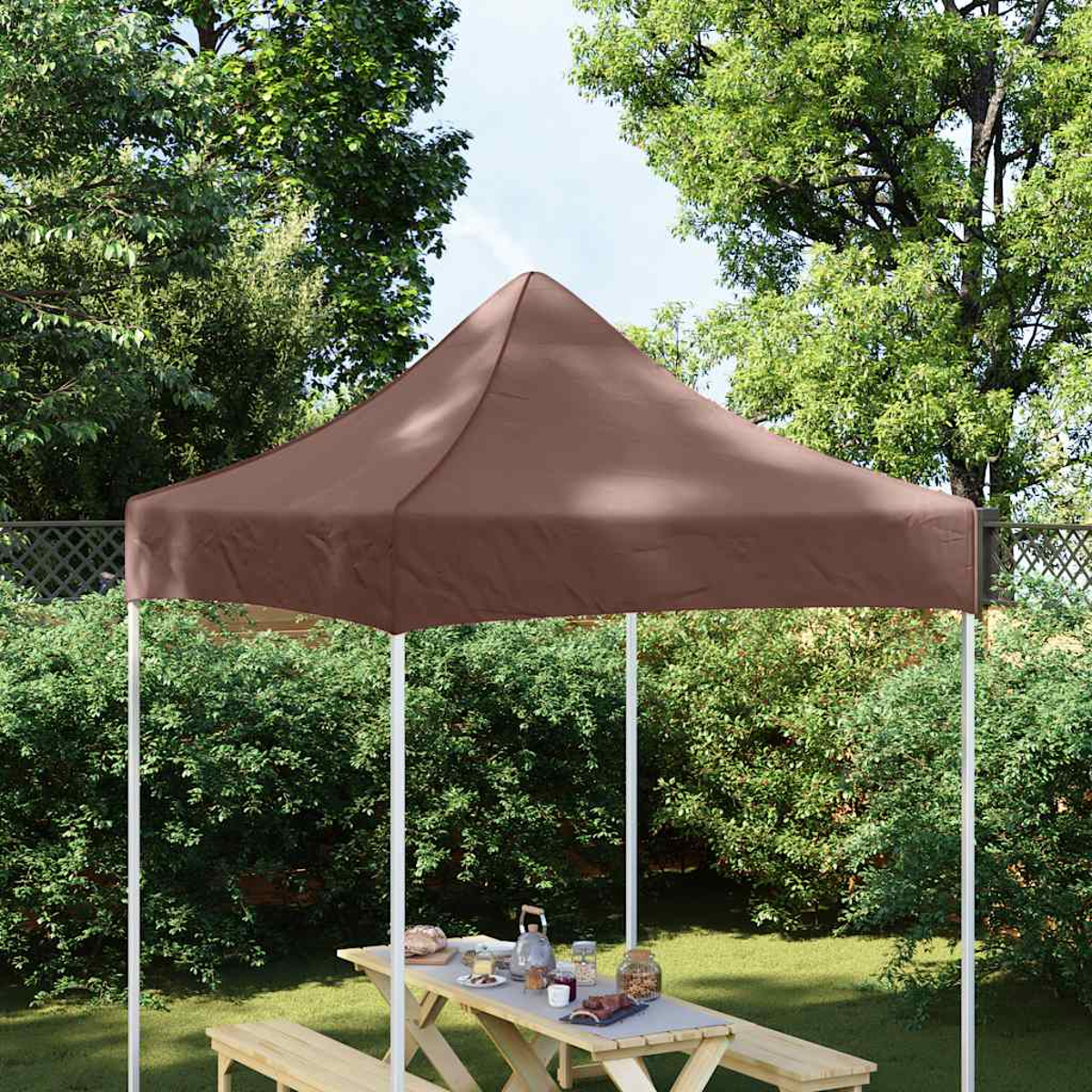 Tenda a baldacchino marrone su tavolo da picnic in legno con panche.