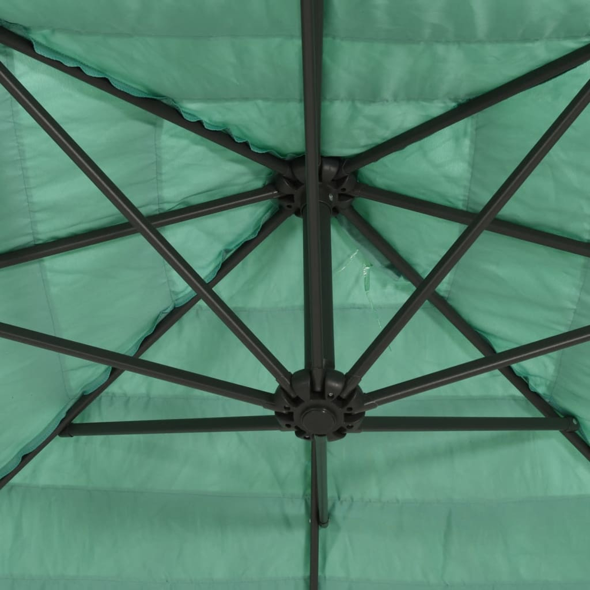 Parte inferiore di un ombrello verde con telaio in metallo grigio e tessuto.