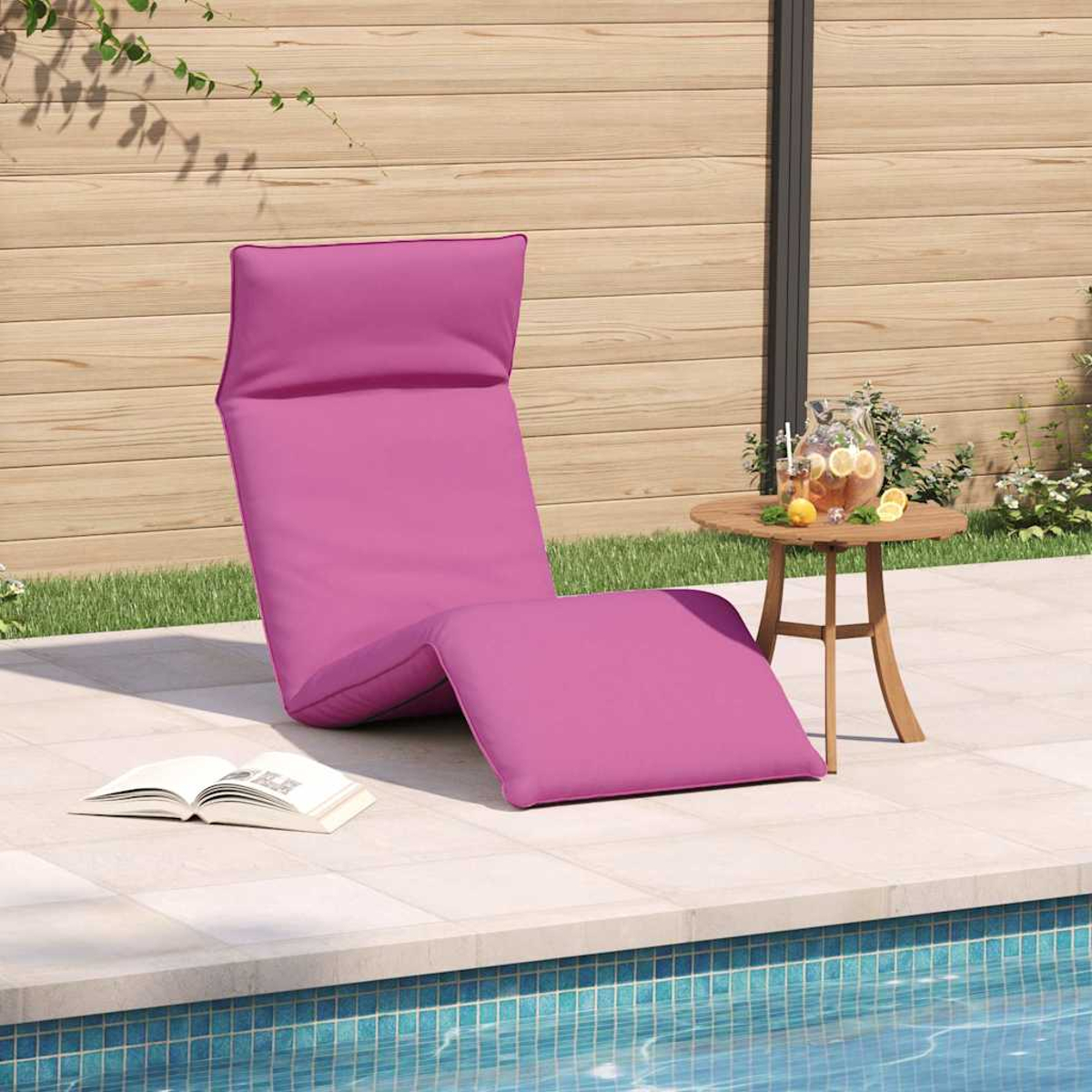 Lila Liege am Pool mit Buch und Limonade auf einem Beistelltisch.
