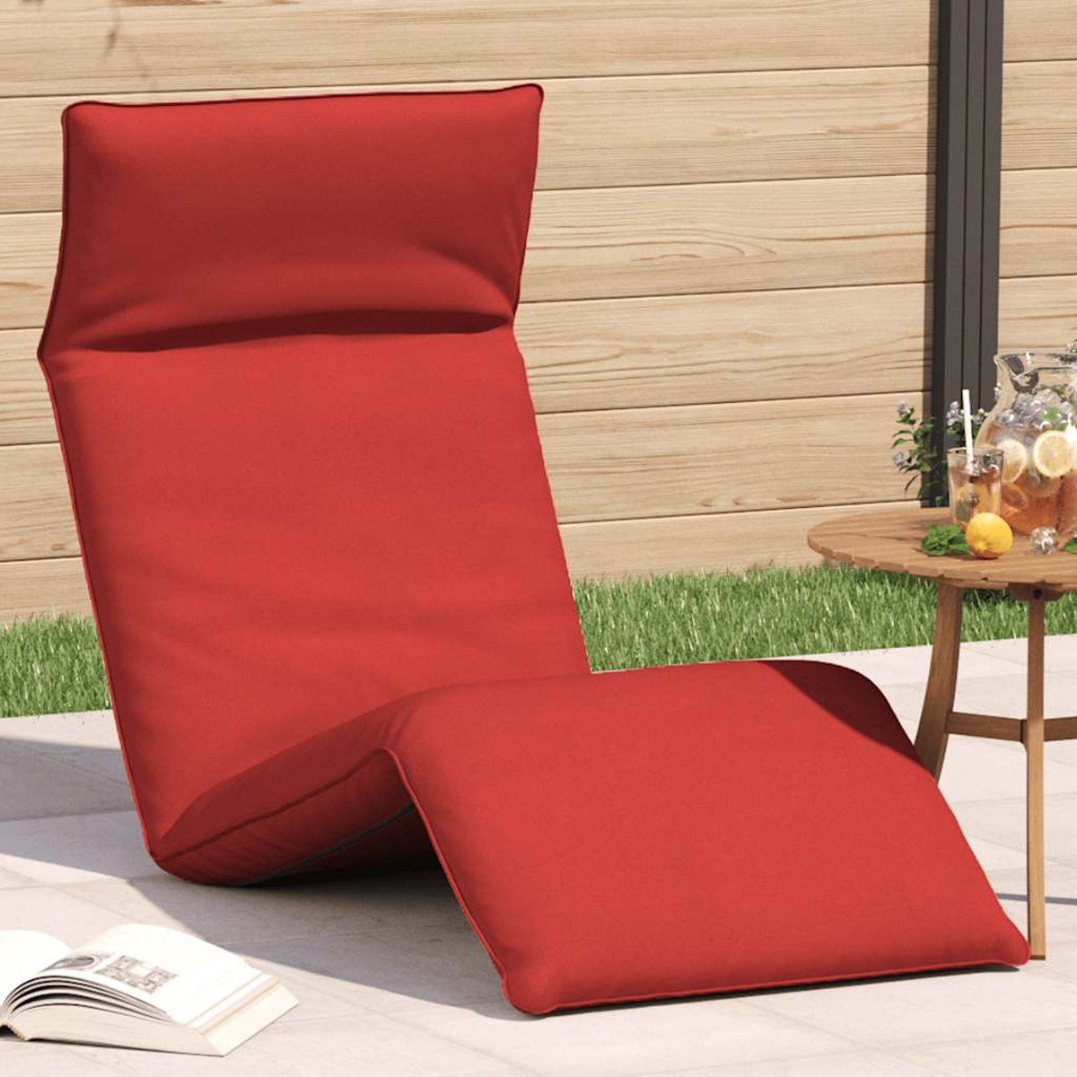 Ein roter Liegestuhl steht auf einer Terrasse neben einem Tisch mit Getränken.