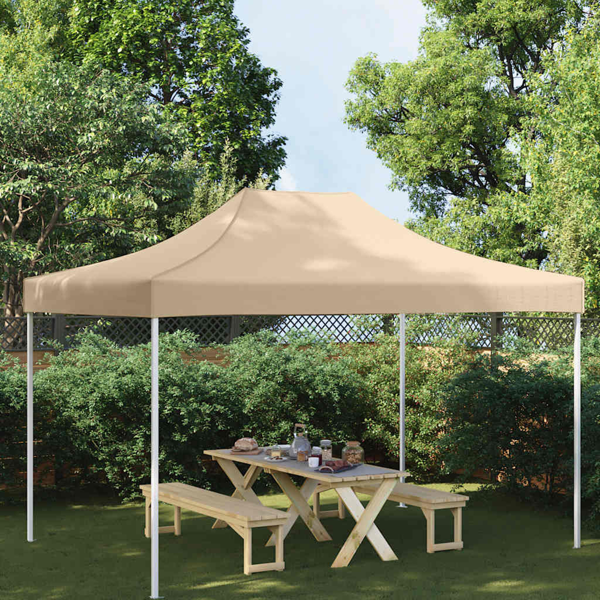 Una tenda color cachi copre un tavolo da picnic con panche in giardino.