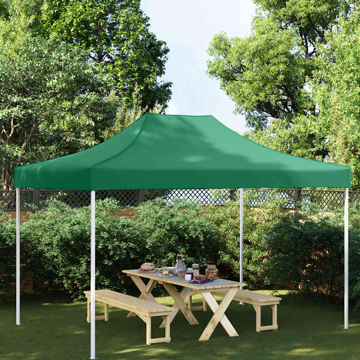 Tenda verde sopra tavolo da picnic in legno con panche.