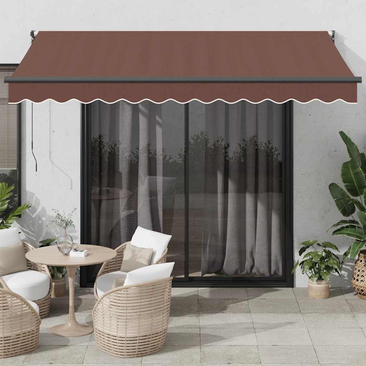 Tessuto marrone di tenda da sole sopra porta finestra, con sedie e tavolo in vimini.