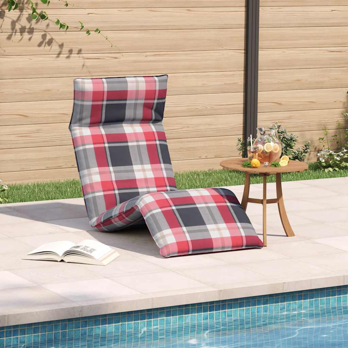 Sdraio a quadri vicino alla piscina con tè freddo e un libro.