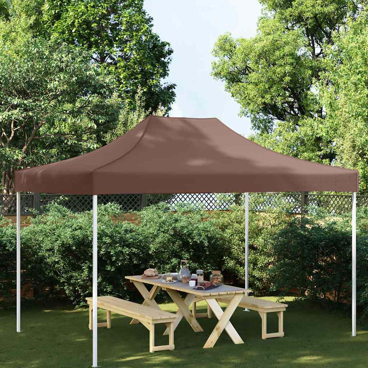 Tenda a baldacchino marrone su tavolo da picnic con panche in giardino.