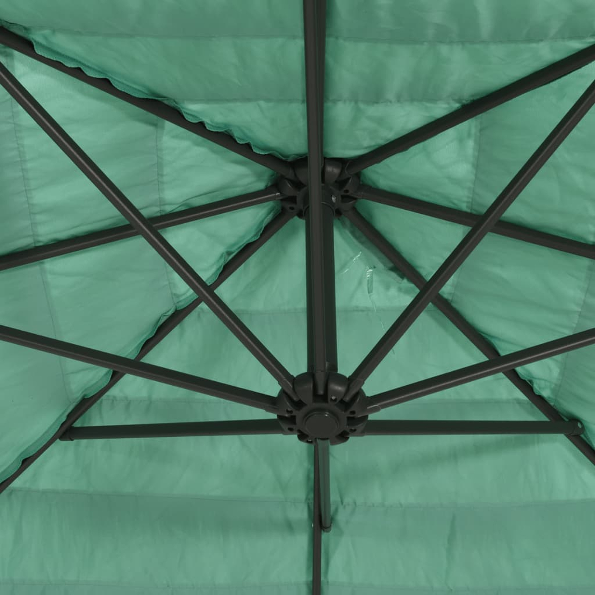 Parte inferiore di un ombrello verde con telaio in metallo scuro e tessuto.