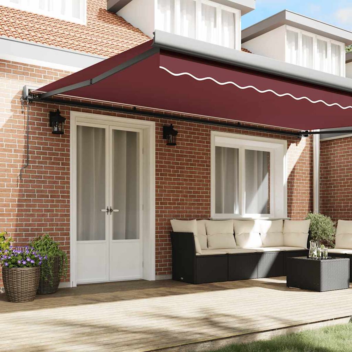 Una tenda da sole color vinaccia su un patio con posti a sedere e piante.