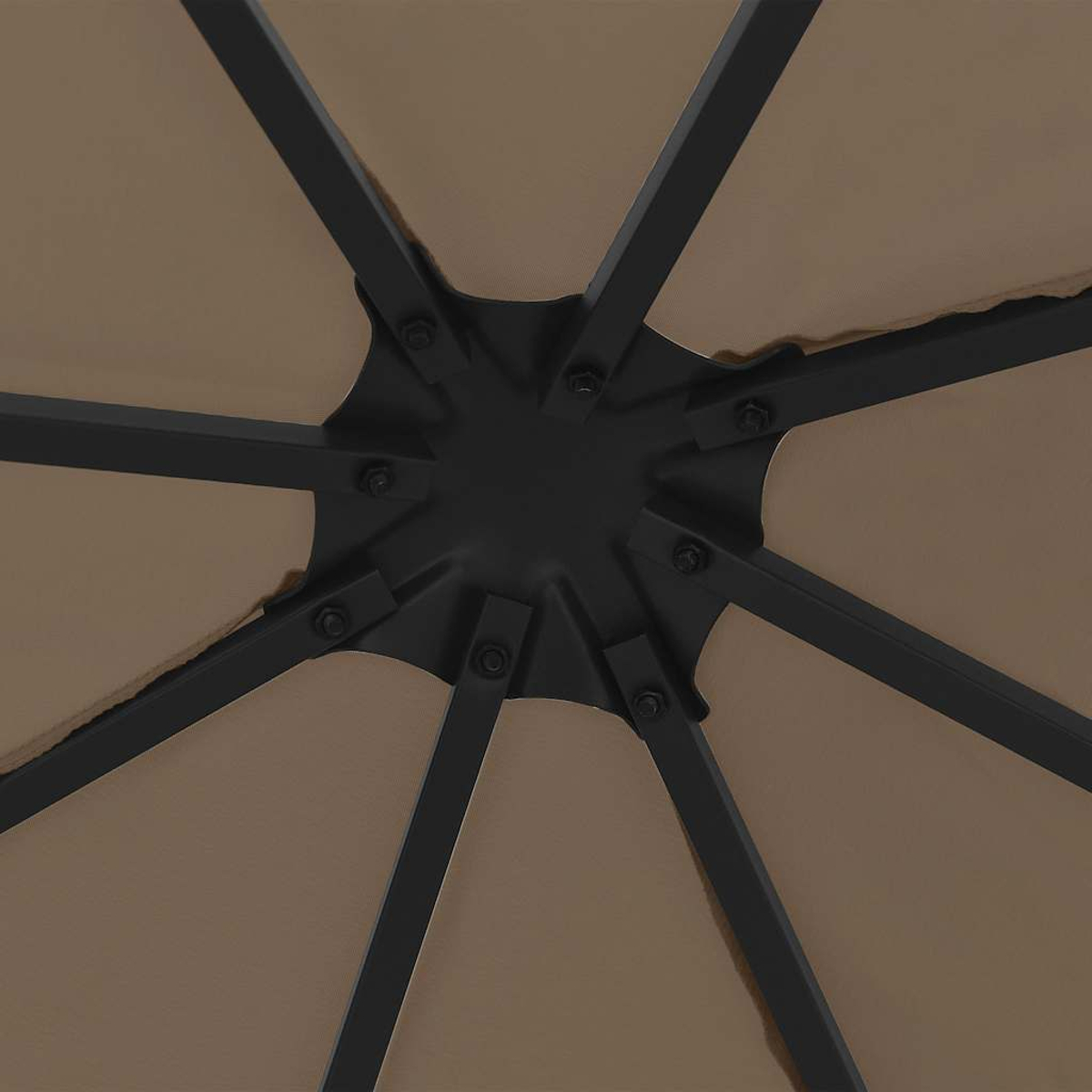 Primo piano di montanti metallici neri che si irradiano da un mozzo centrale, sostenendo una tettoia in tessuto beige.