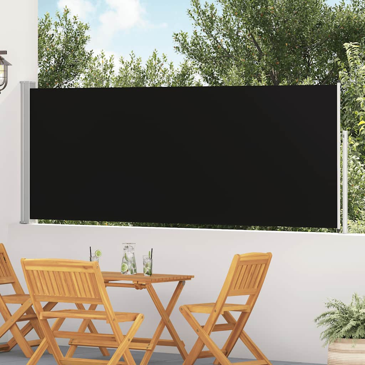 Tendalino retrattile nero su patio con sedie e tavolo in legno.