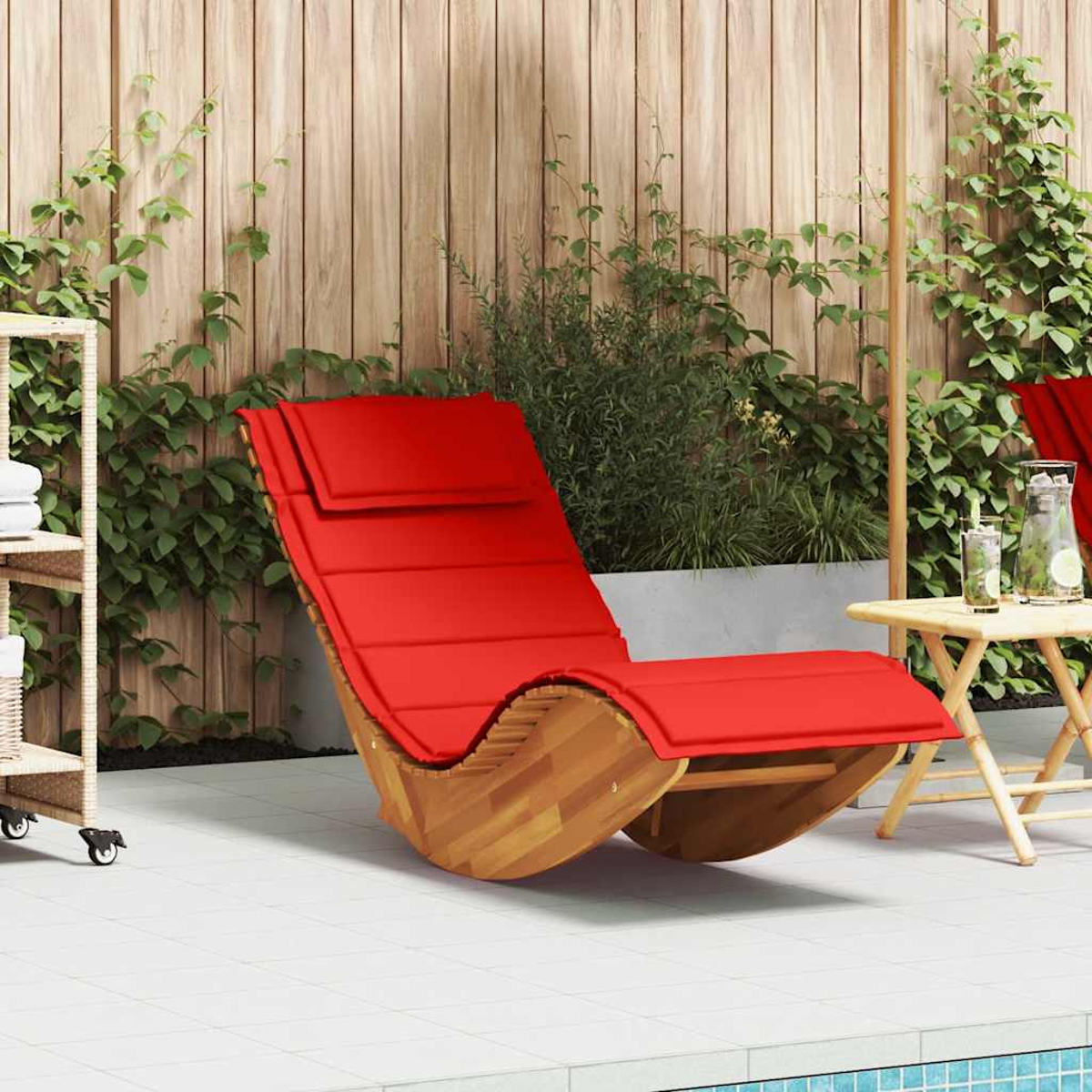Ein roter Schaukelstuhl aus Holz steht auf einer gefliesten Terrasse neben einem Tisch mit Getränken.