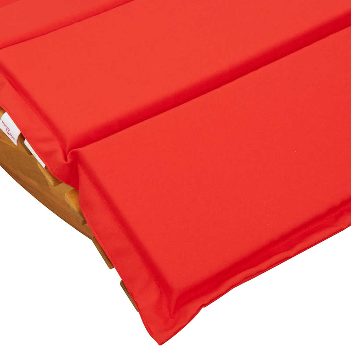 Rotes Polster auf einer Holzliege, Nahaufnahme.