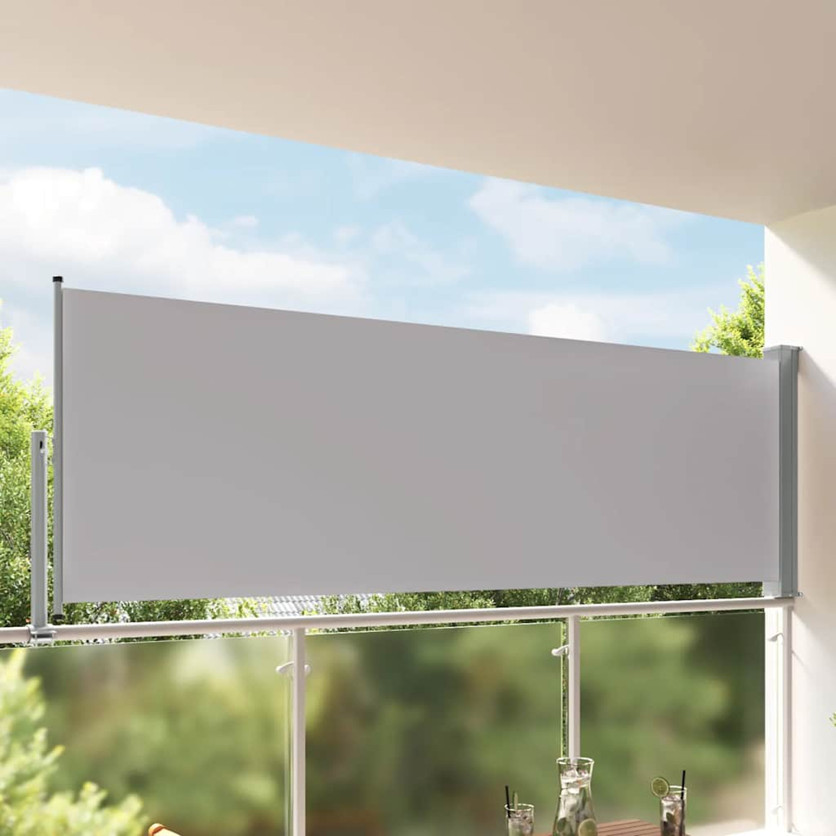Una tenda da sole retrattile grigia su un balcone con alberi e cielo blu.