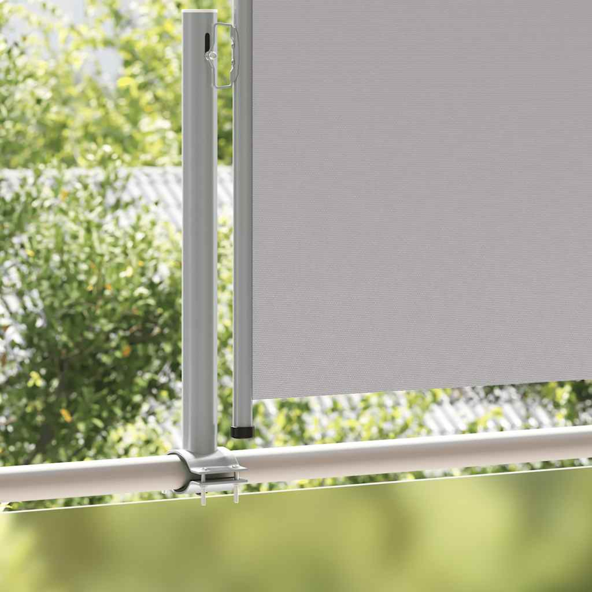 Tenda a rullo grigia su ringhiera del balcone con fogliame verde.