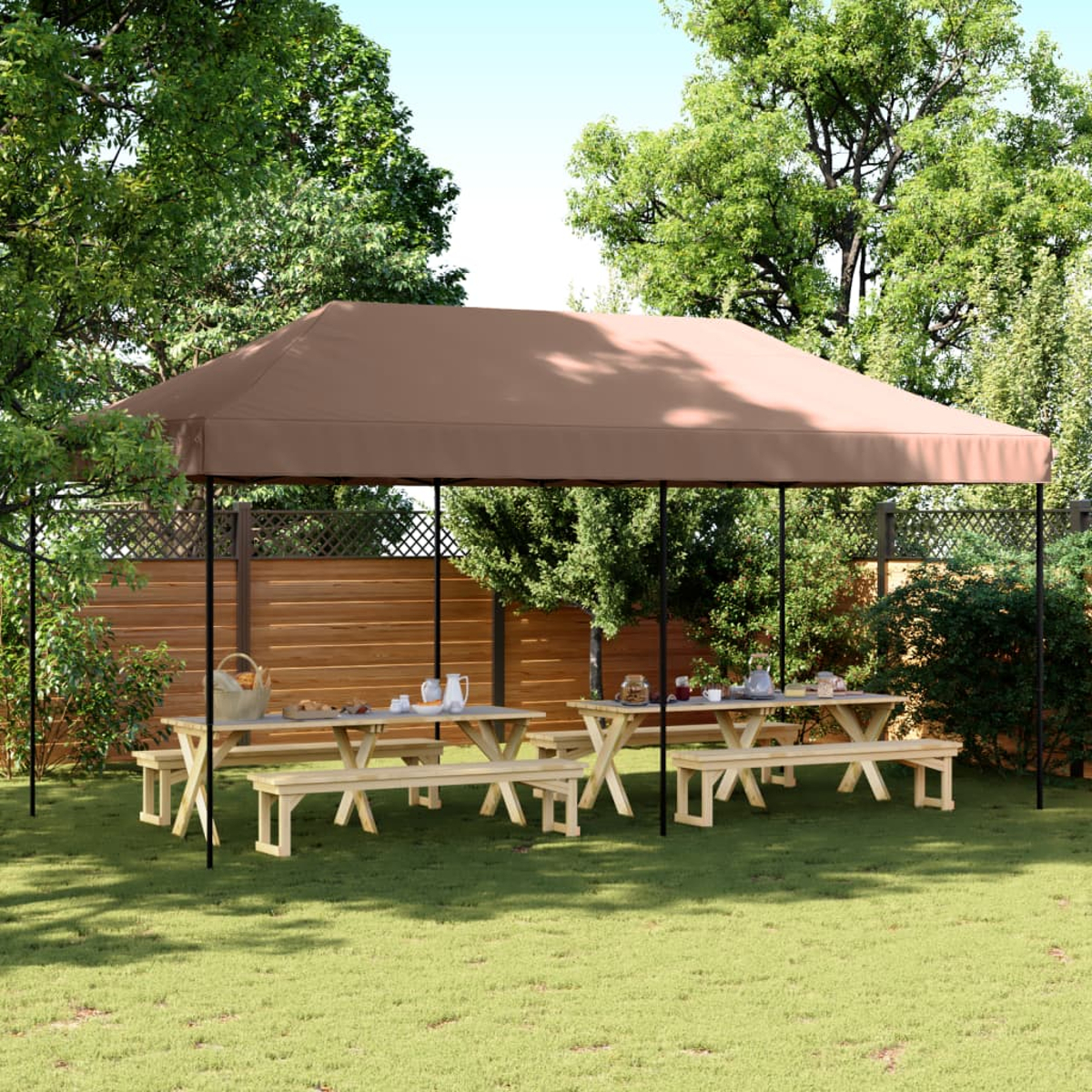 Due tavoli da picnic in legno con panche sotto una tettoia marrone in un giardino.