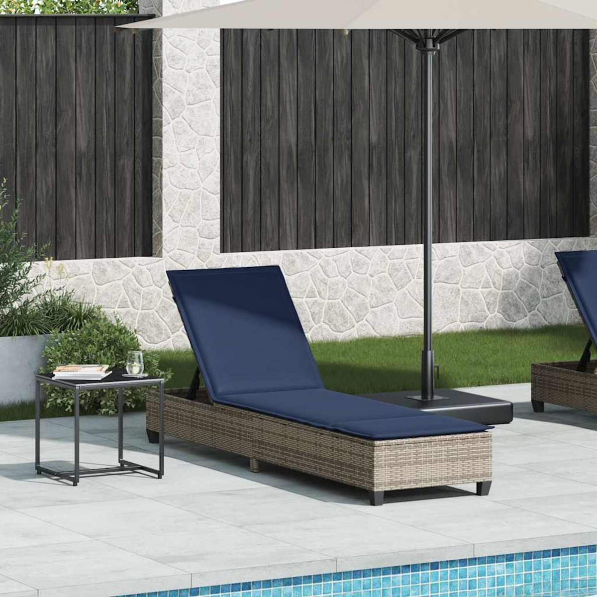 Una chaise longue blu con cuscini si trova accanto a un tavolo e un ombrellone all'aperto.