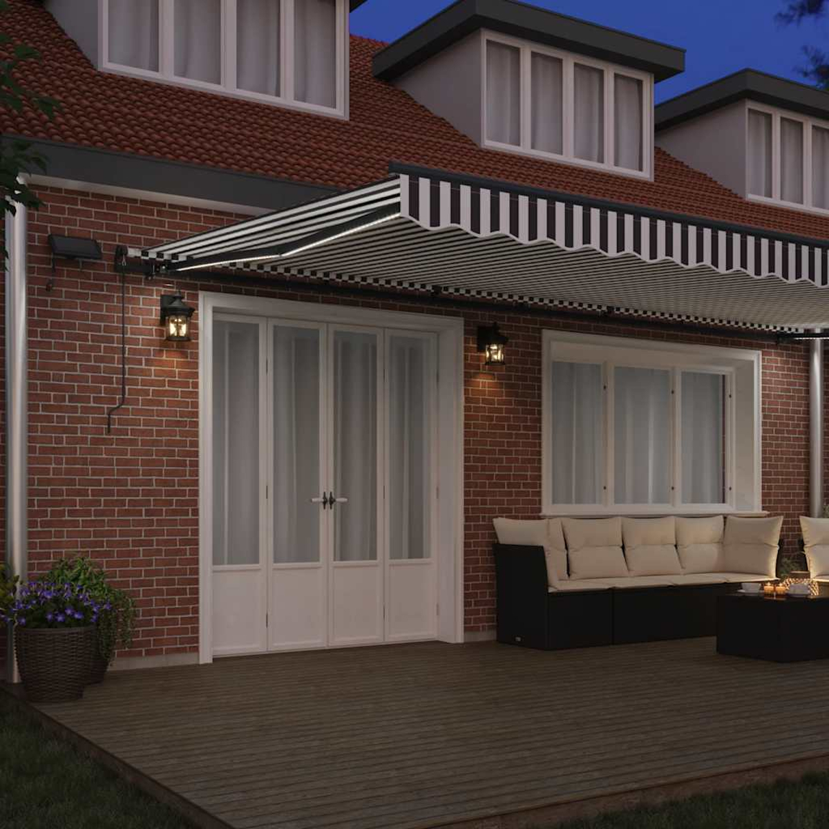Una casa con tenda a righe, mobili da giardino e tavolo.