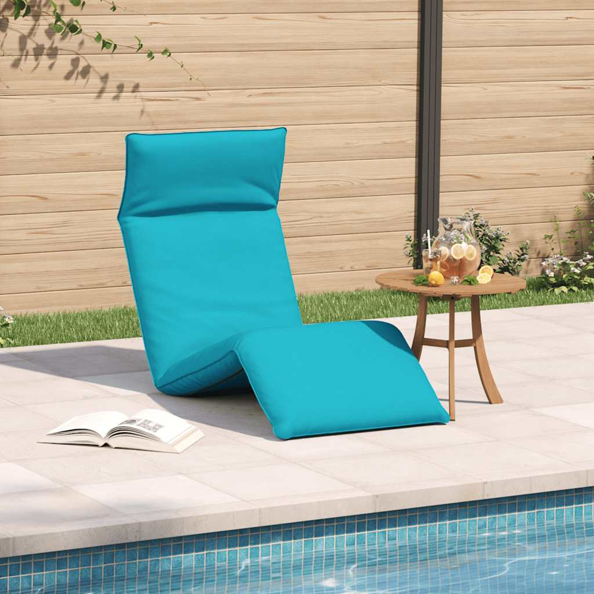 Ein türkisfarbener Liegestuhl steht am Pool, daneben ein kleiner Tisch mit Getränken.
