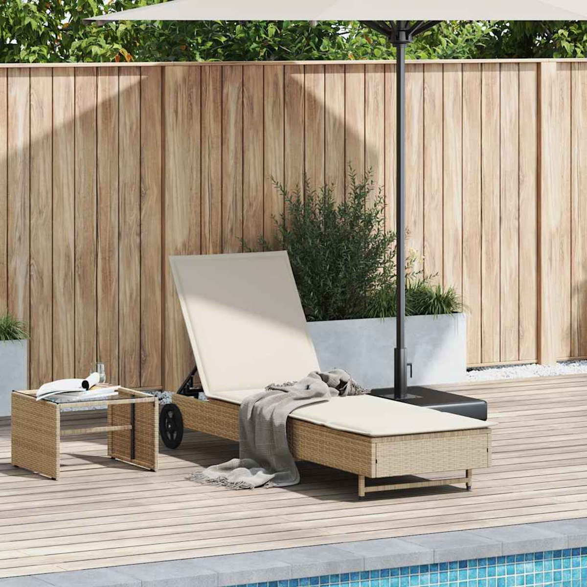 Una sdraio beige con cuscino e coperta su un ponte di legno vicino a un tavolo e una piscina.