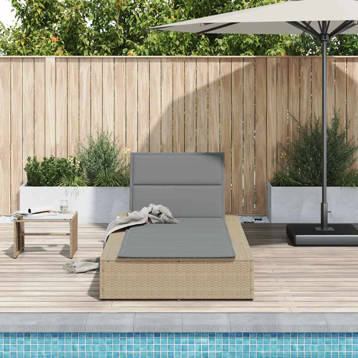 Ein Liegestuhl mit grauer Polsterung steht auf einer Holzterrasse neben einem Pool.