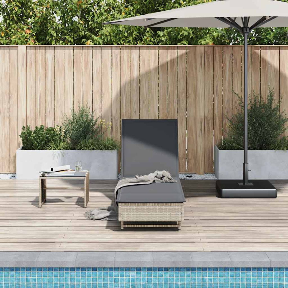 Una sdraio e un ombrellone vicino a una piscina con recinzione in legno e fioriere.