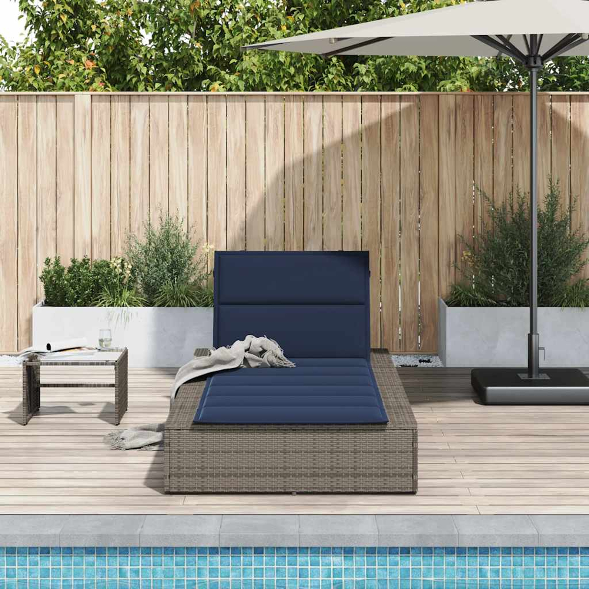 Ein blauer Liegestuhl mit Kissen steht auf einer Holzterrasse neben einem Pool.