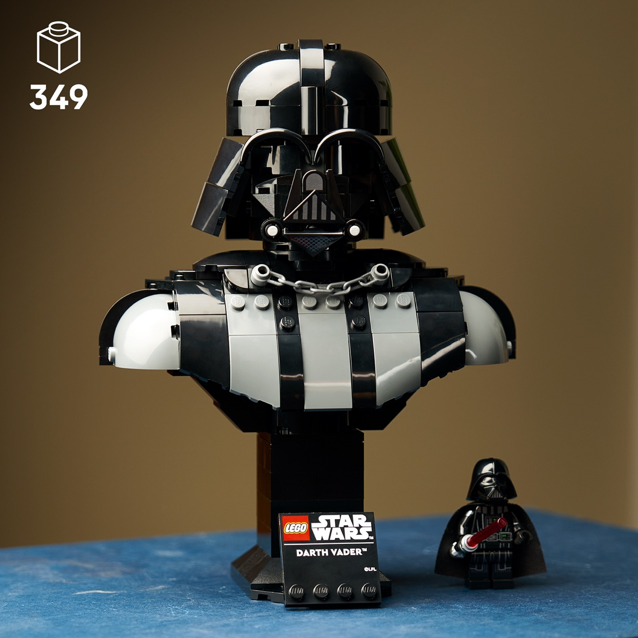 Un set di busto Lego di Darth Vader con una piccola figura su sfondo blu.