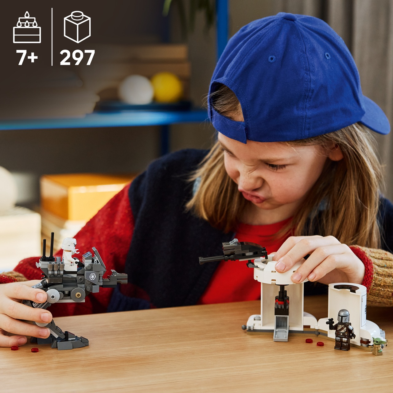 Un niño arma un set de Lego con figuras de Star Wars sobre una mesa de madera.