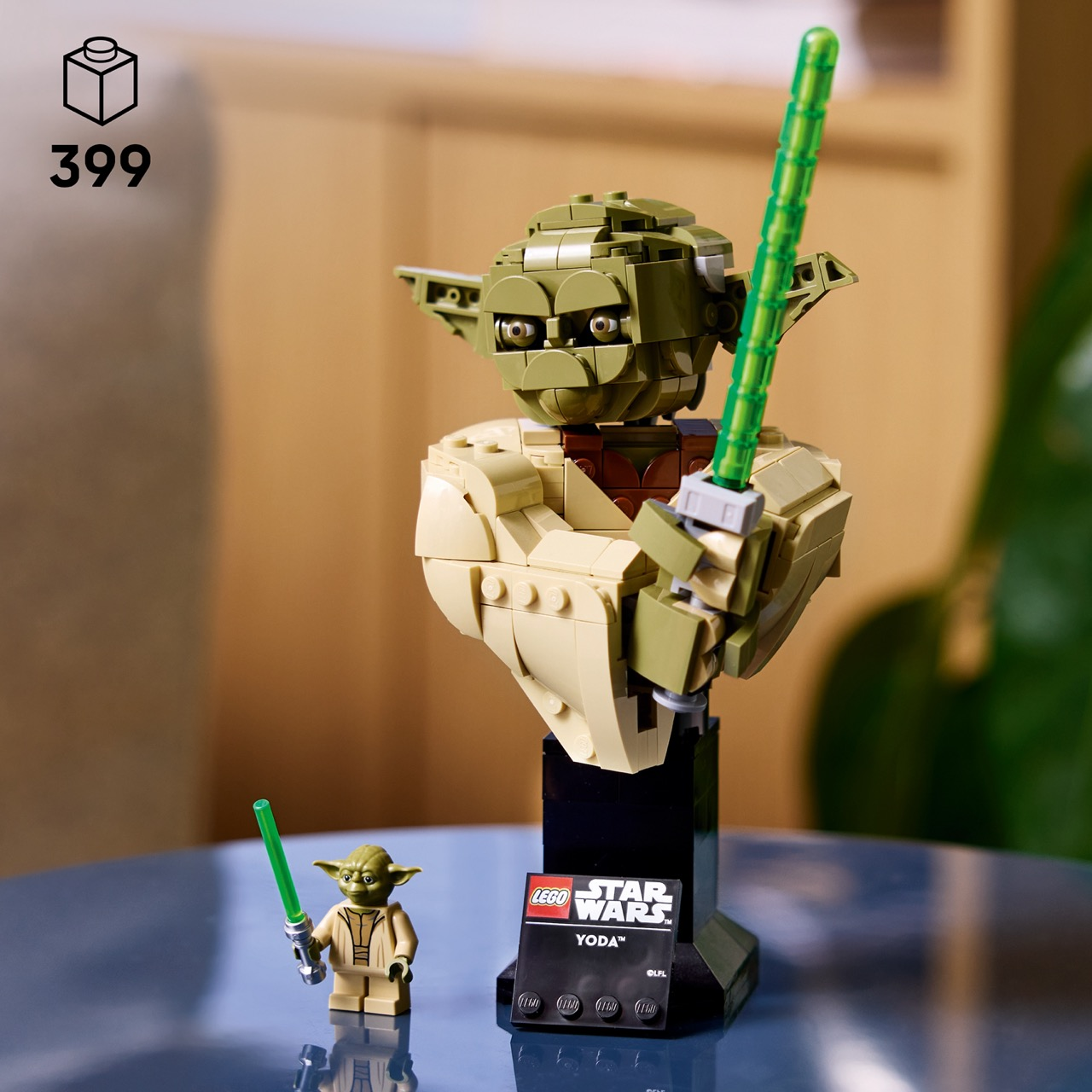 Busto e minifigure Lego di Yoda con spade laser verdi su un tavolo.