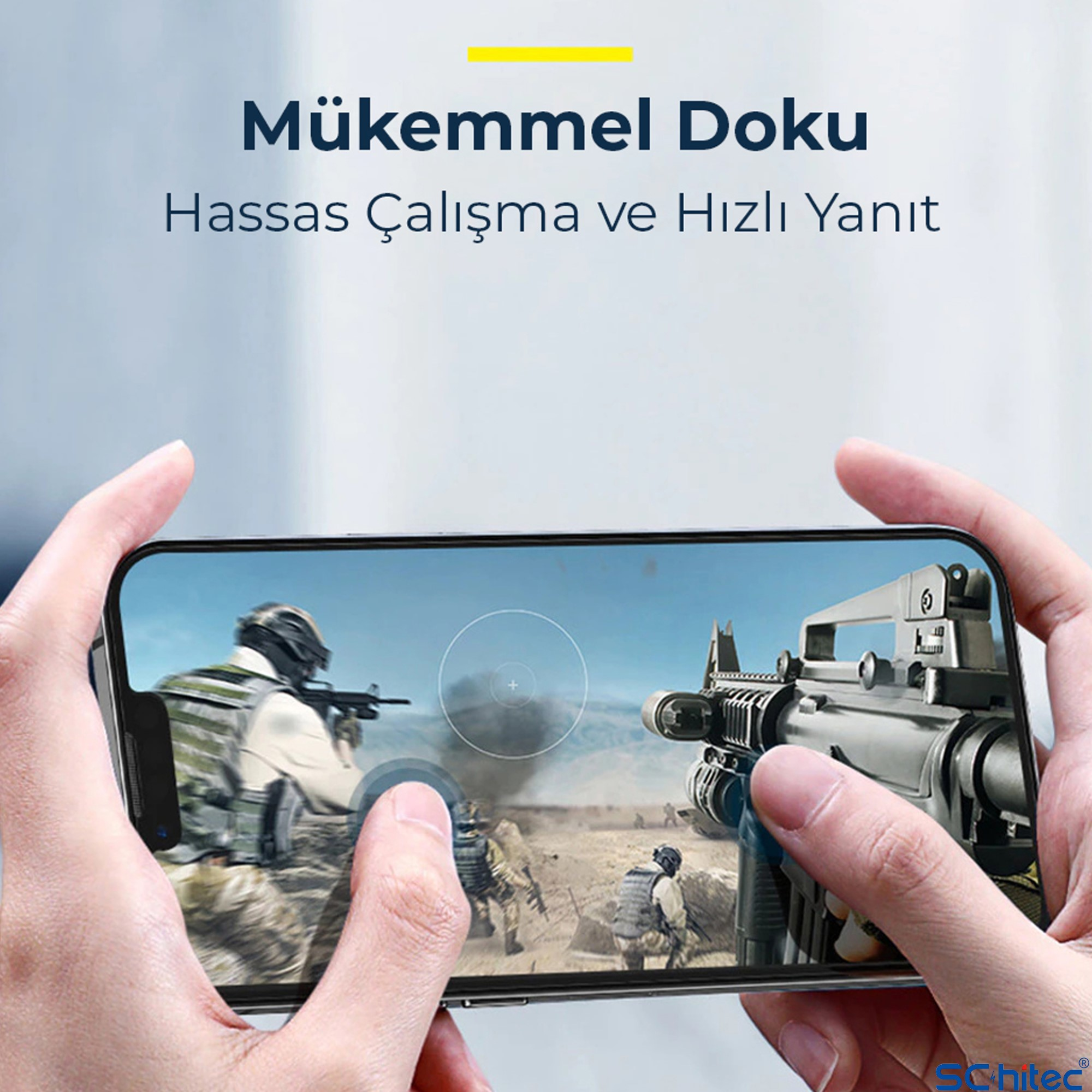Eller savaş oyunu gösteren akıllı telefonu tutuyor. Bir asker silahla nişan alıyor.