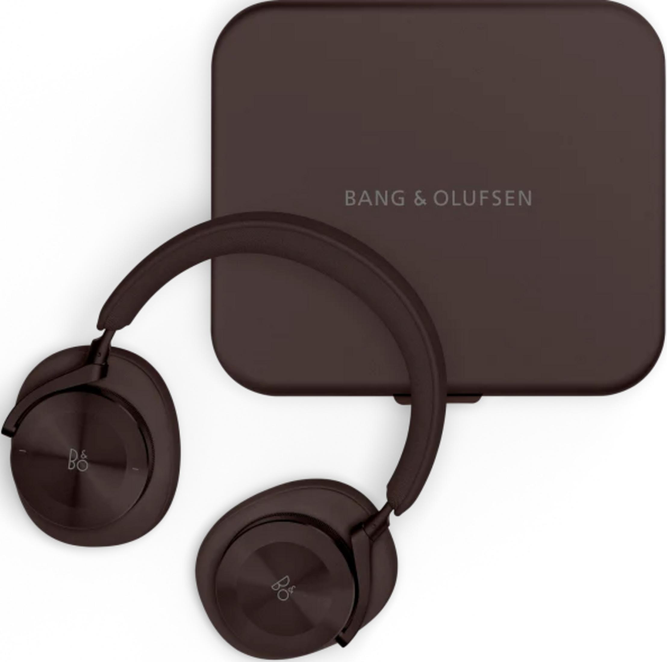 Braune Bang & Olufsen Kopfhörer liegen neben ihrer Ladebox.