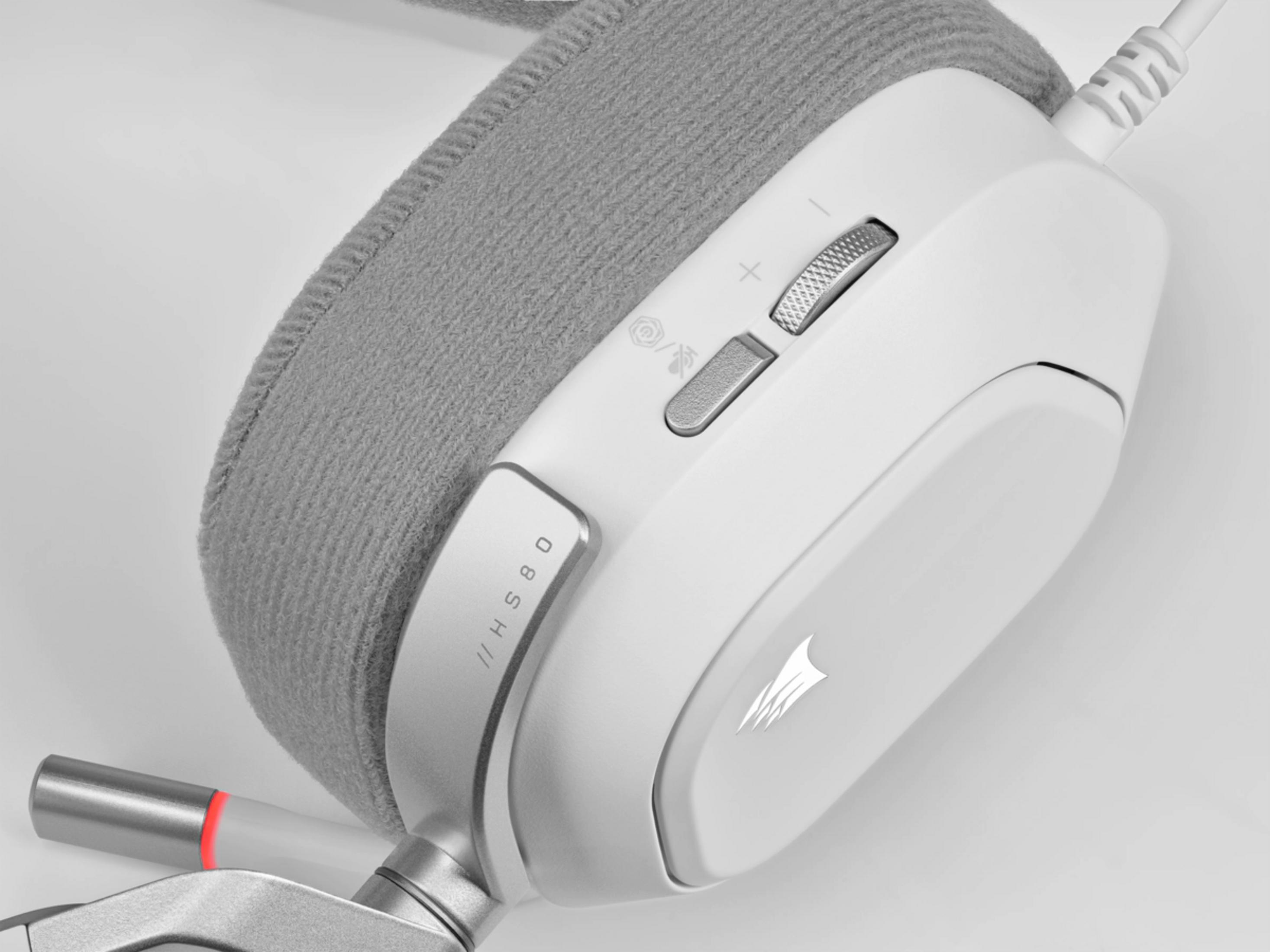 Weißes Gaming-Headset mit grauem Stoffkopfbügel. Lautstärkedrehregler und Mikrofon-Stummschalttaste sichtbar.