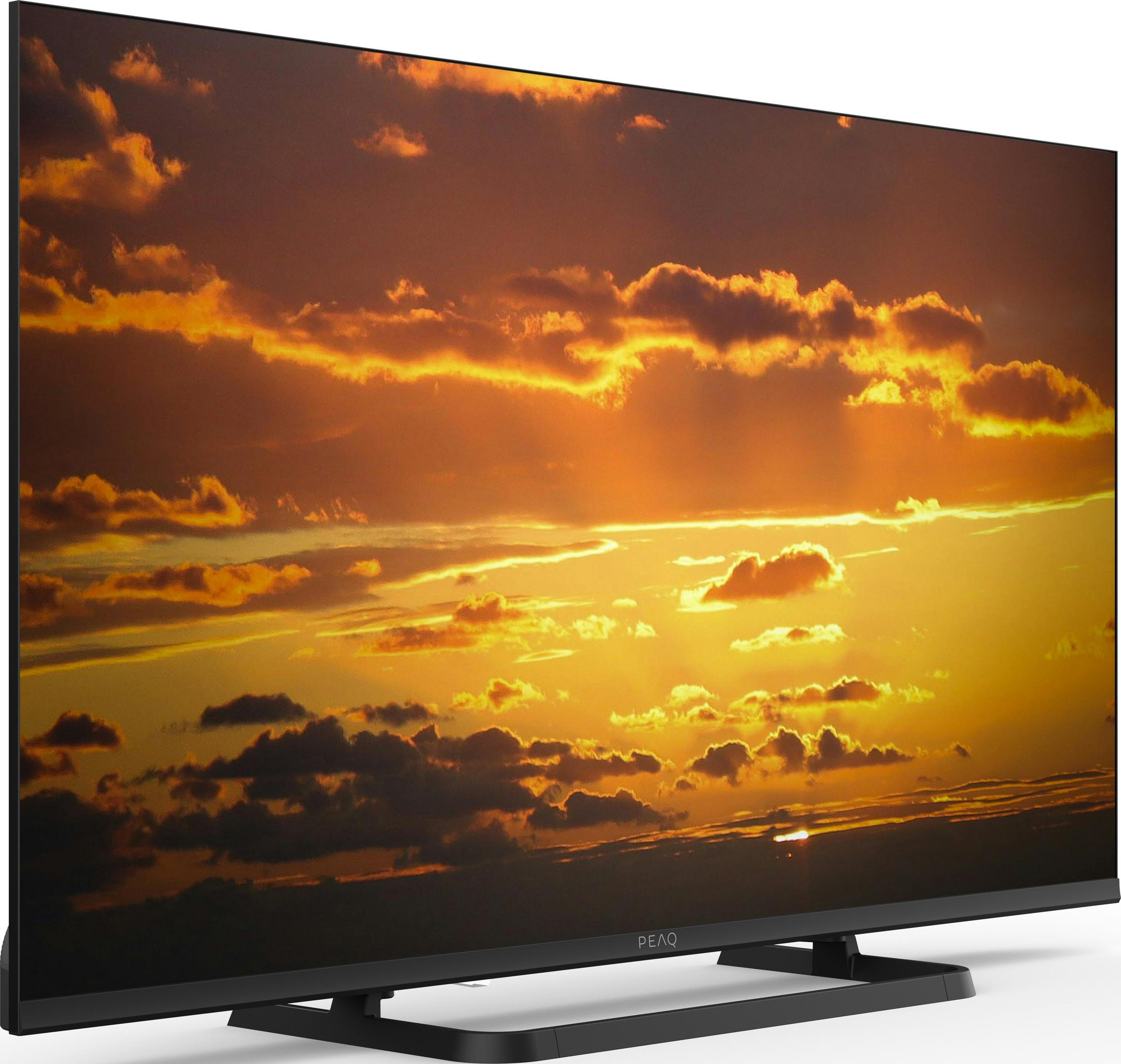 Ein schwarzer Fernseher zeigt einen dramatischen Sonnenuntergang mit orangefarbenen Wolken.