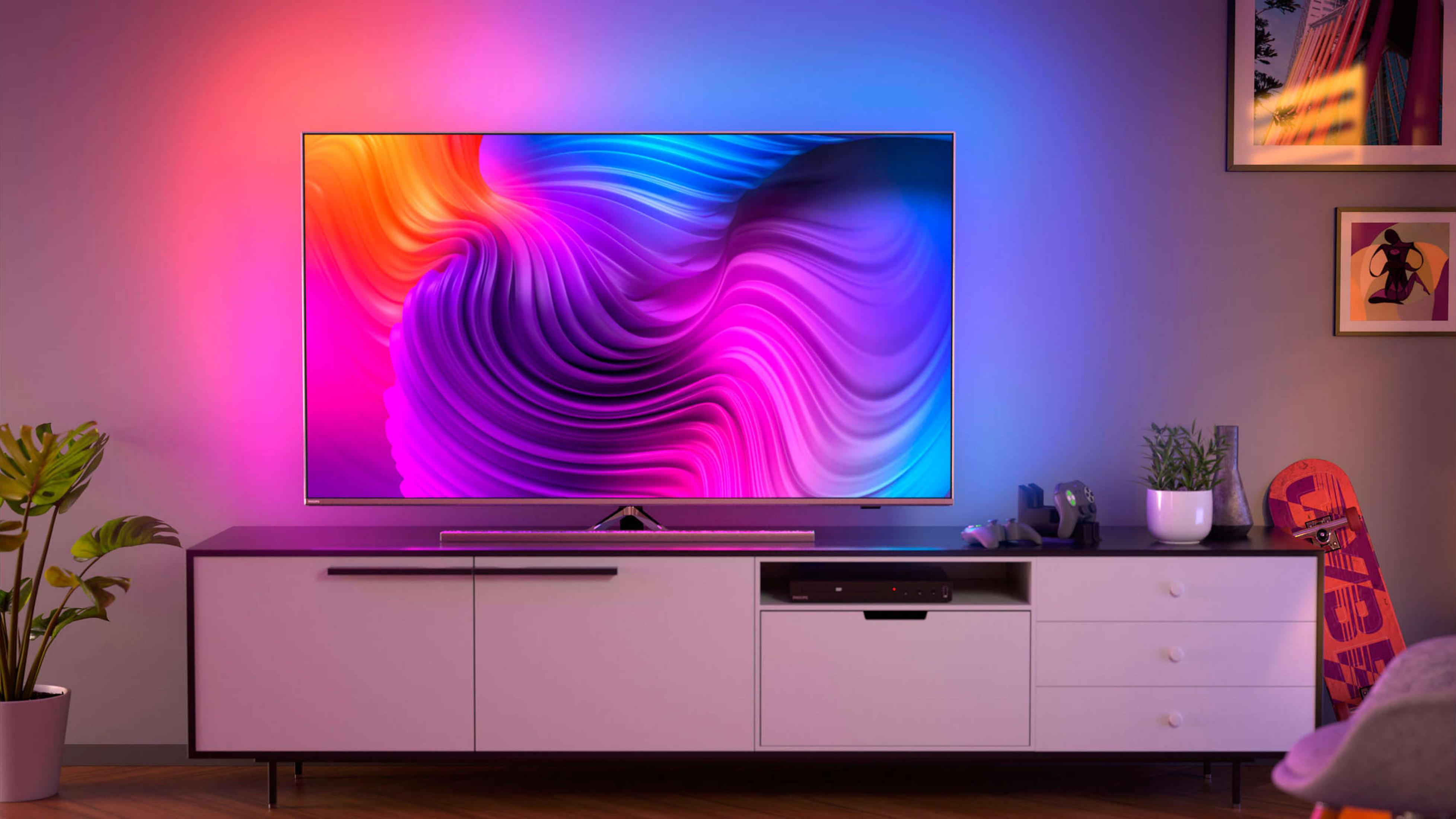 Moderne tv met kleurrijke abstracte kunst, op een wit tv-meubel met decoratie.