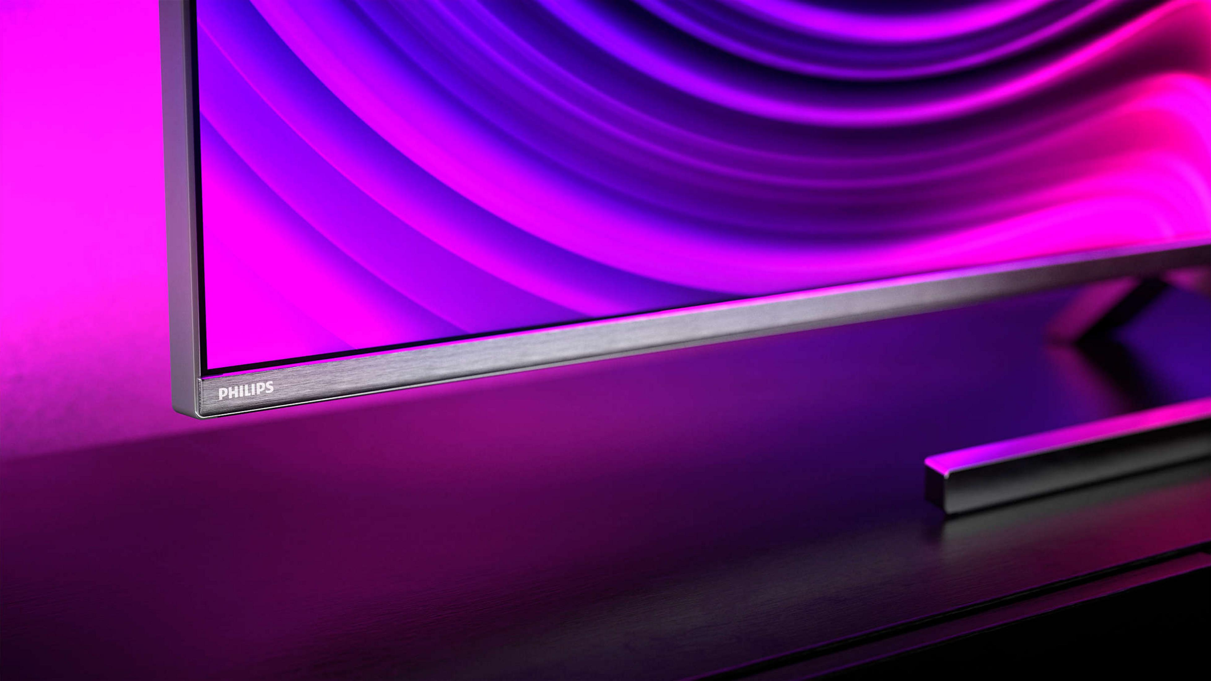 Close-up van een moderne tv met zilveren rand en paars-roze gradiëntscherm.