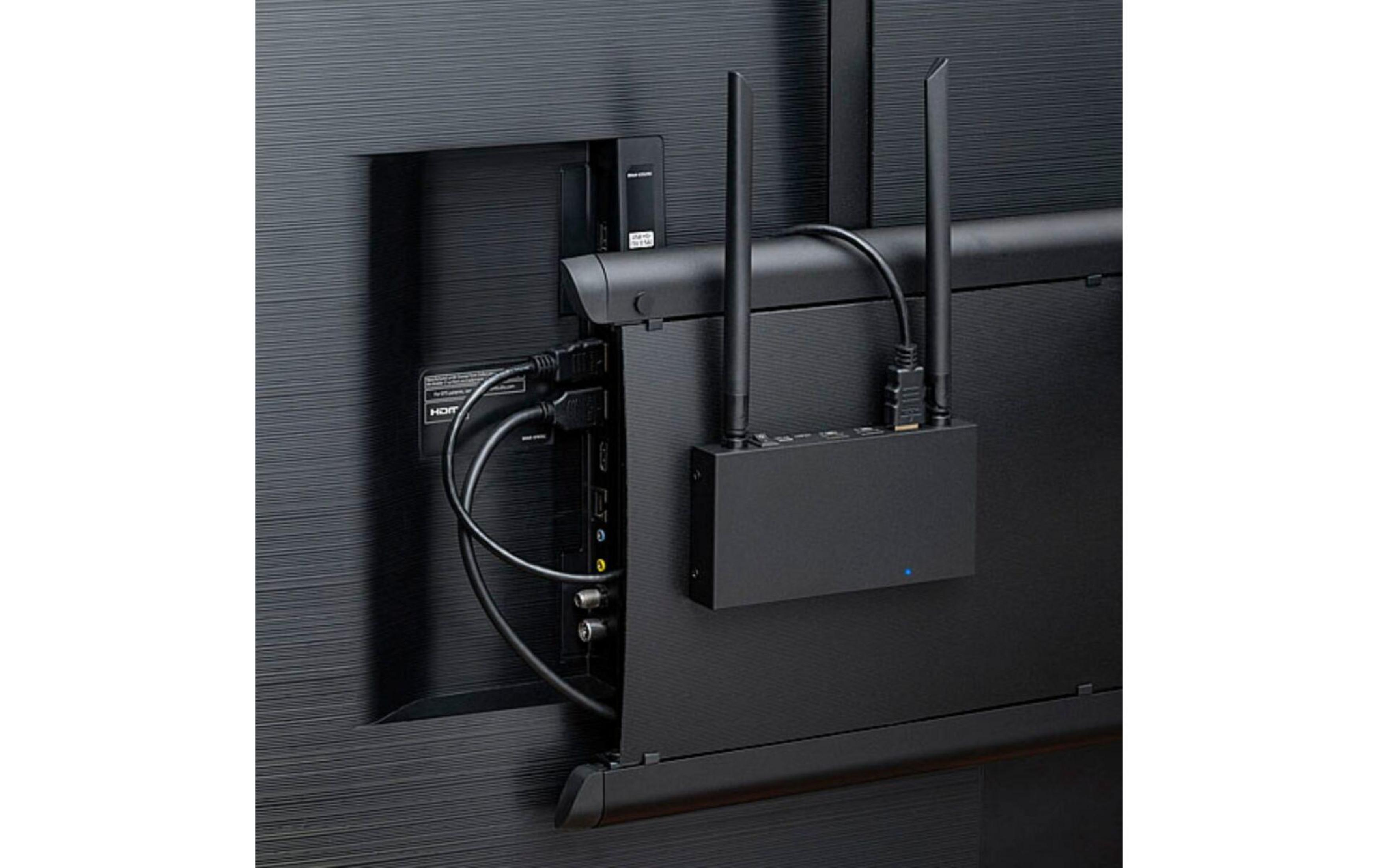 A black box with two antennas connected to the back of a TV.